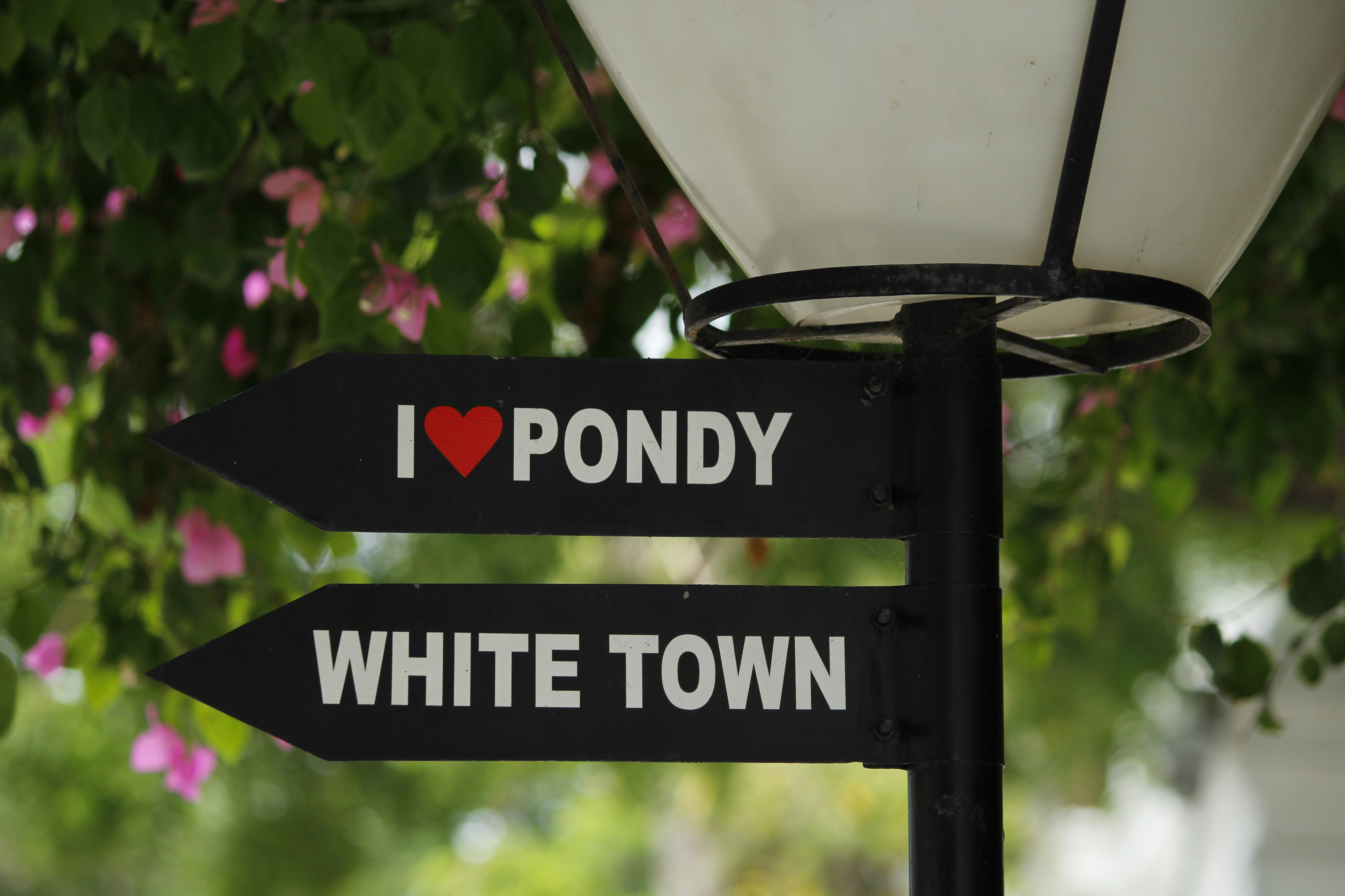 Directional signs for "i love pondy" and "white town"