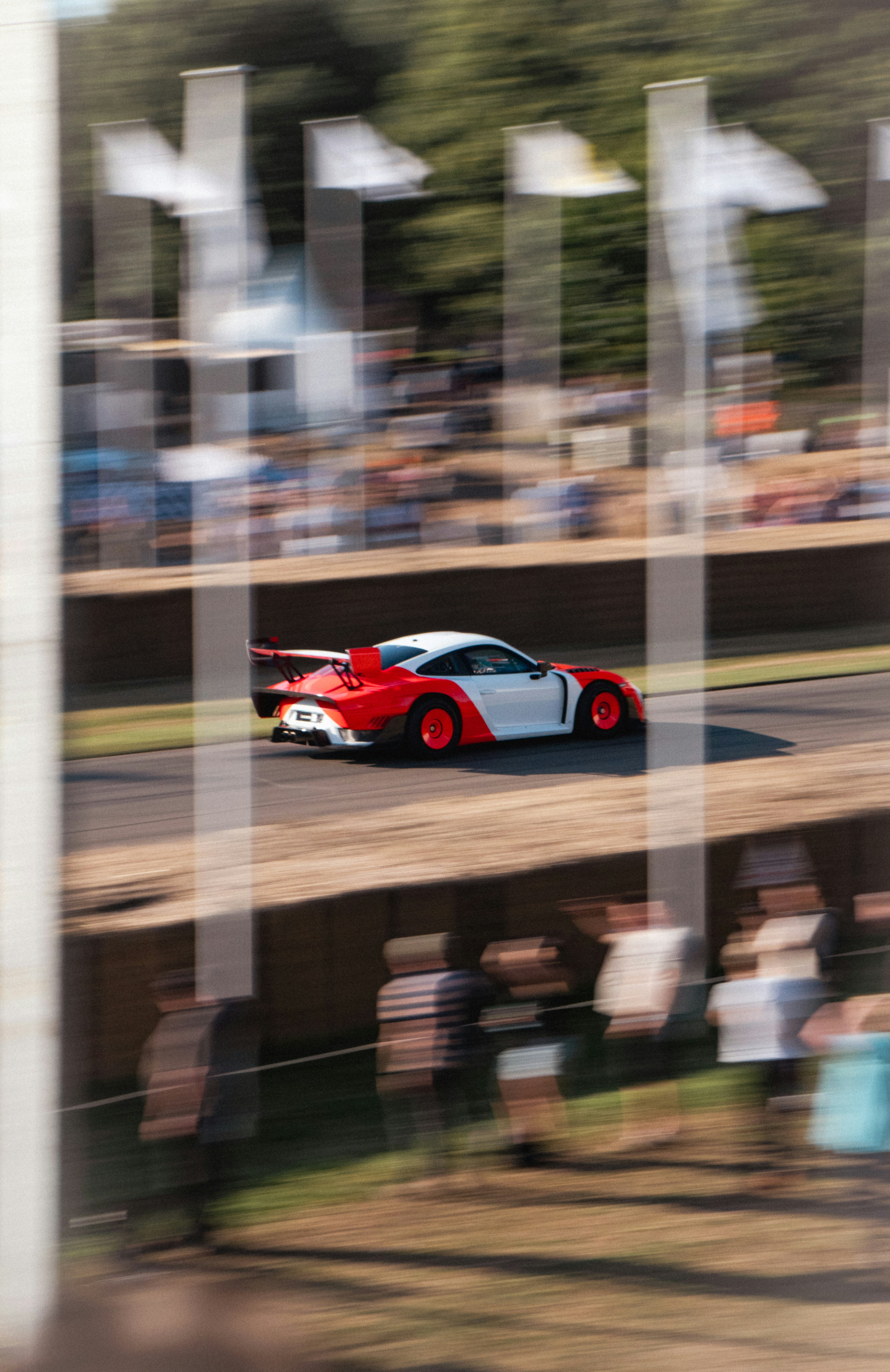 Race car speeding past spectators at a track