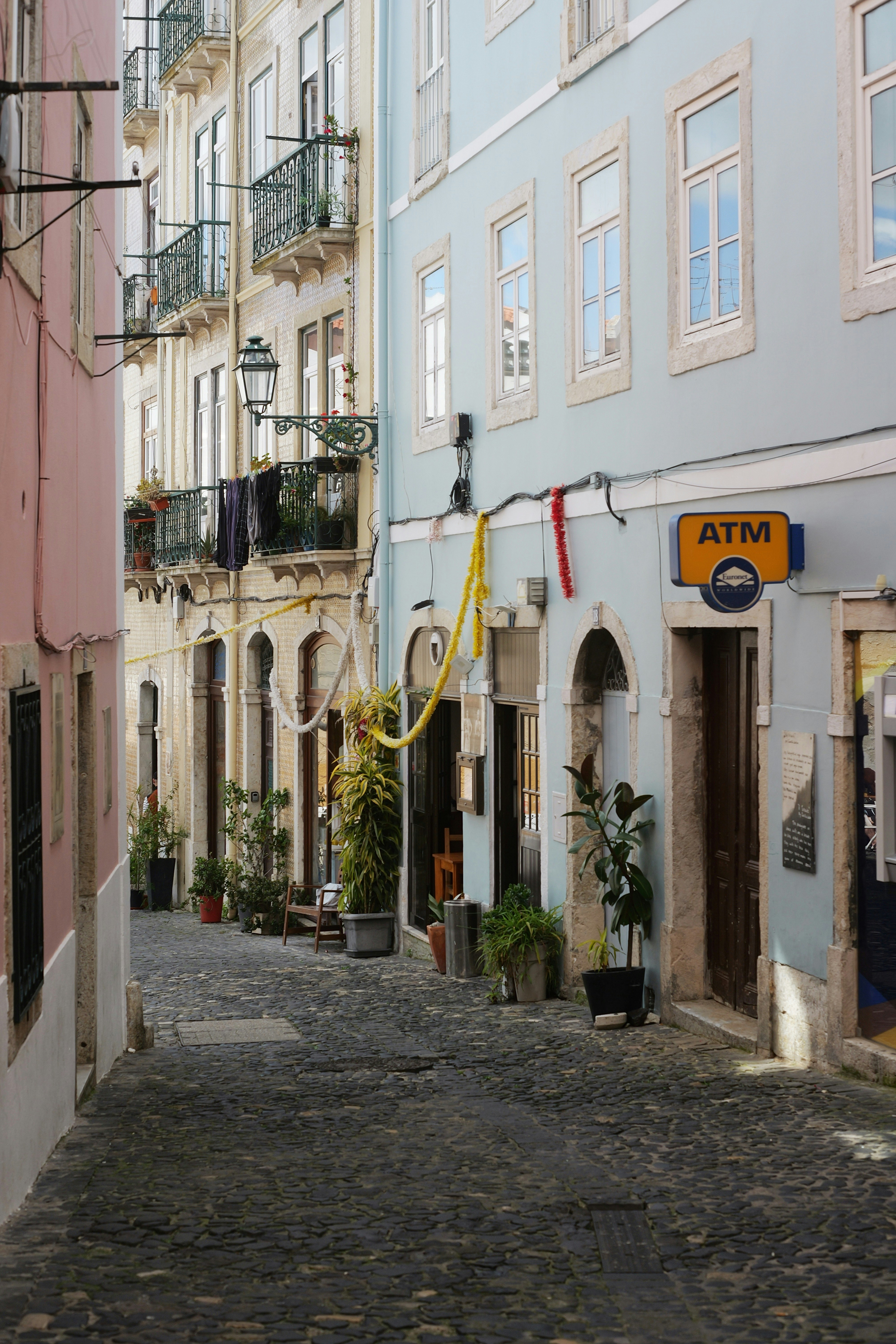 Cobblestone street lined with colorful buildings and shops.