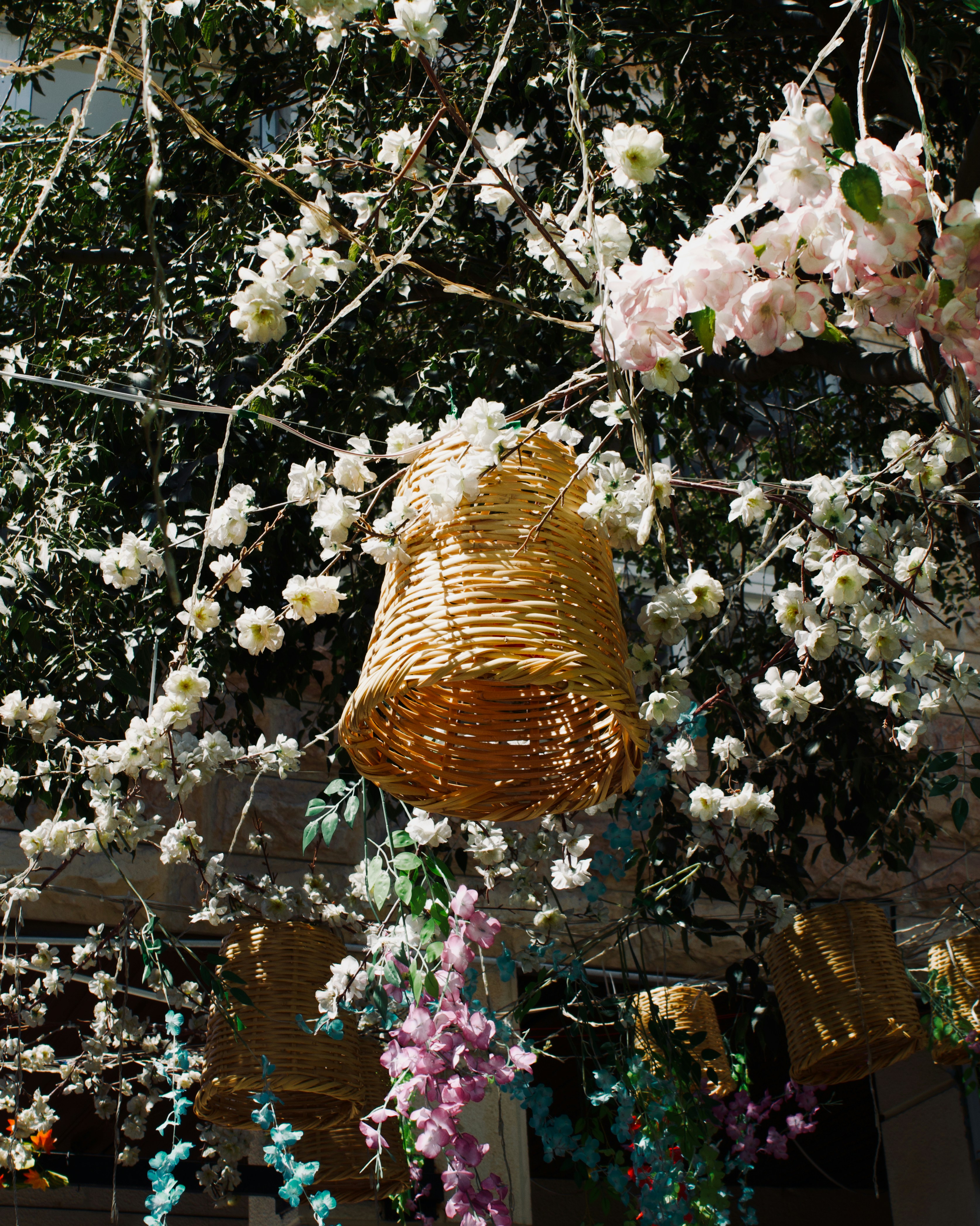 Woven baskets hanging among blooming flowers