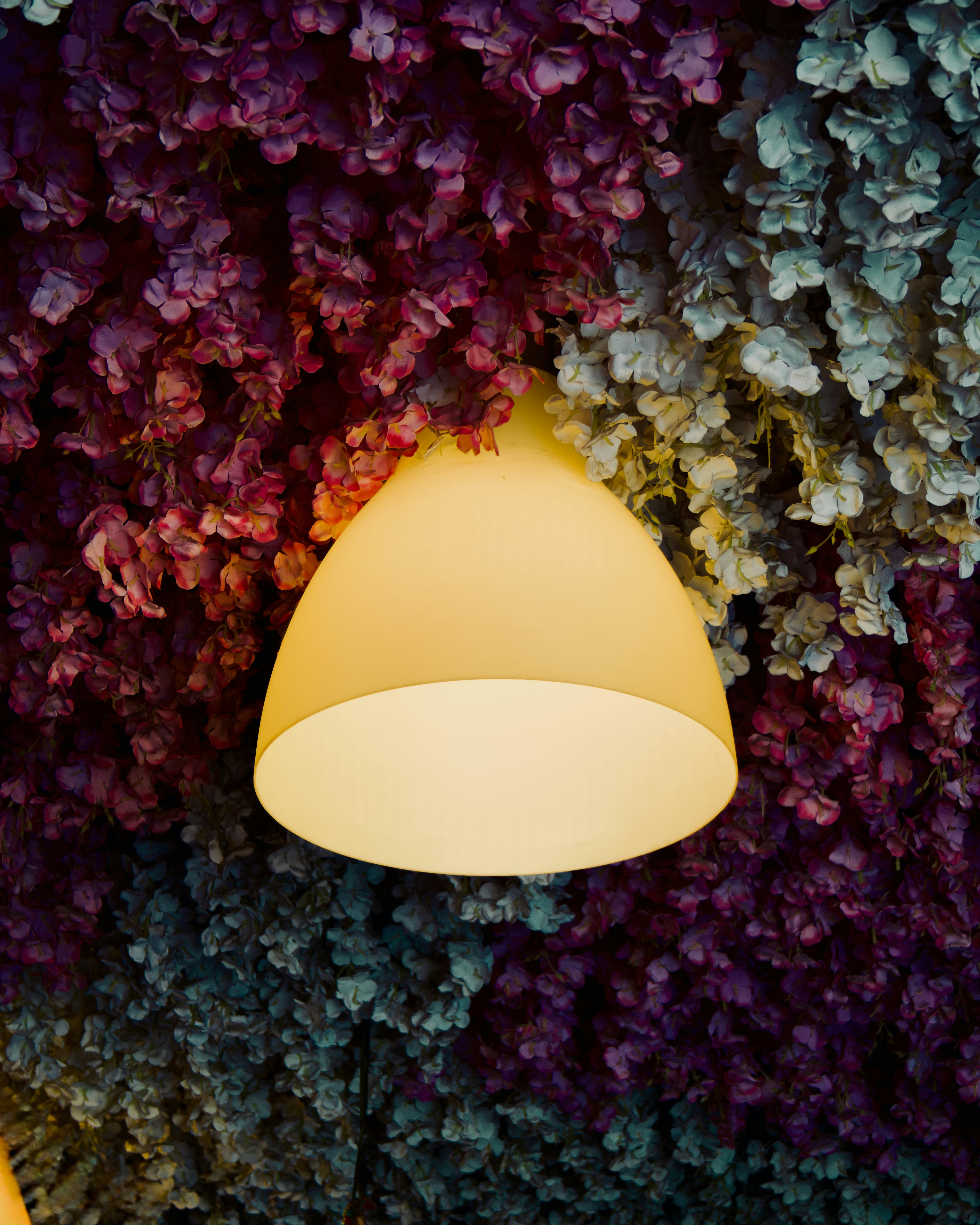 A pendant light hangs amidst colorful floral decorations.