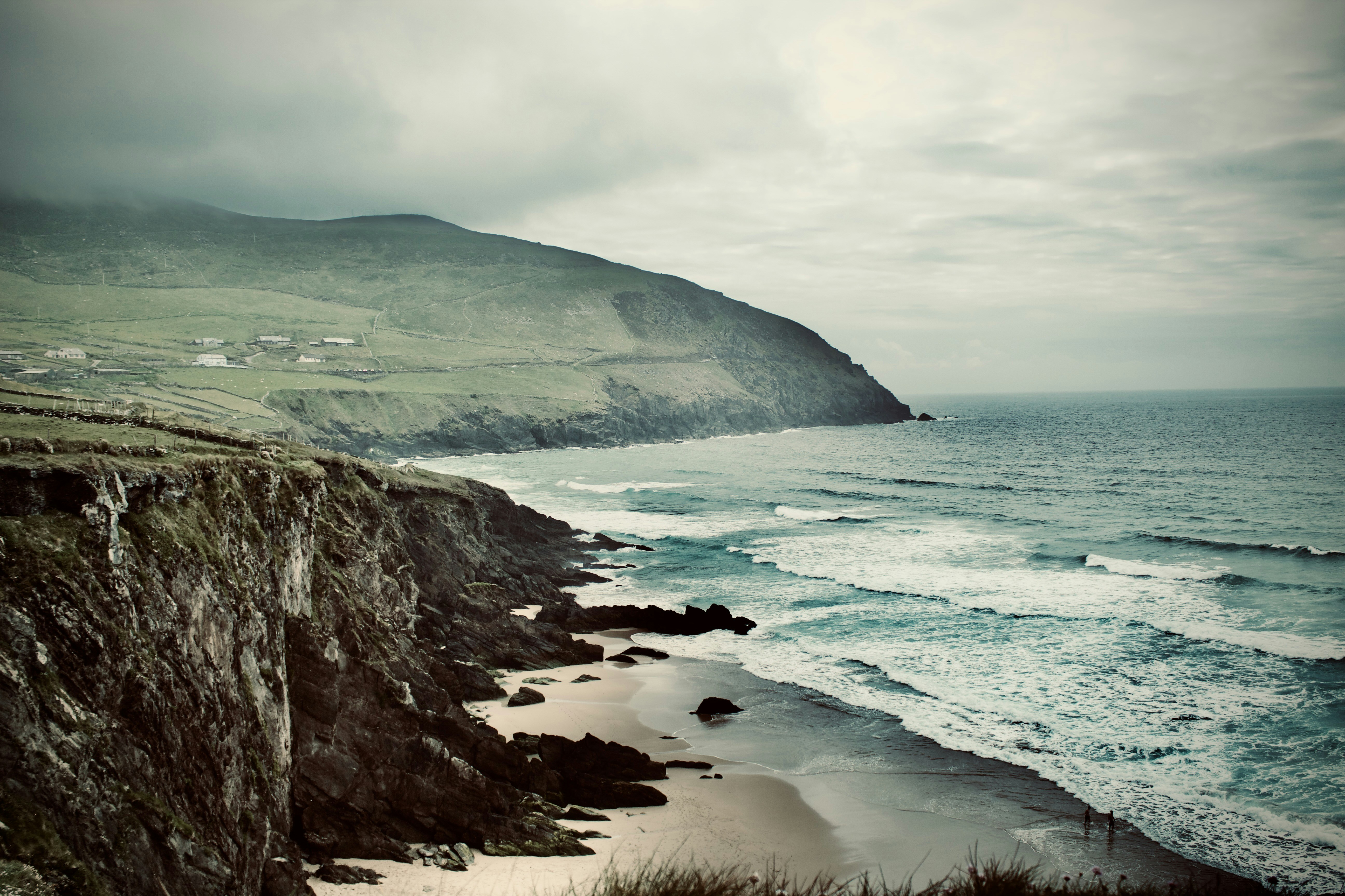 遠くにヨットがある岩だらけの海岸の絵の写真 – Unsplashの芸術の無料画像