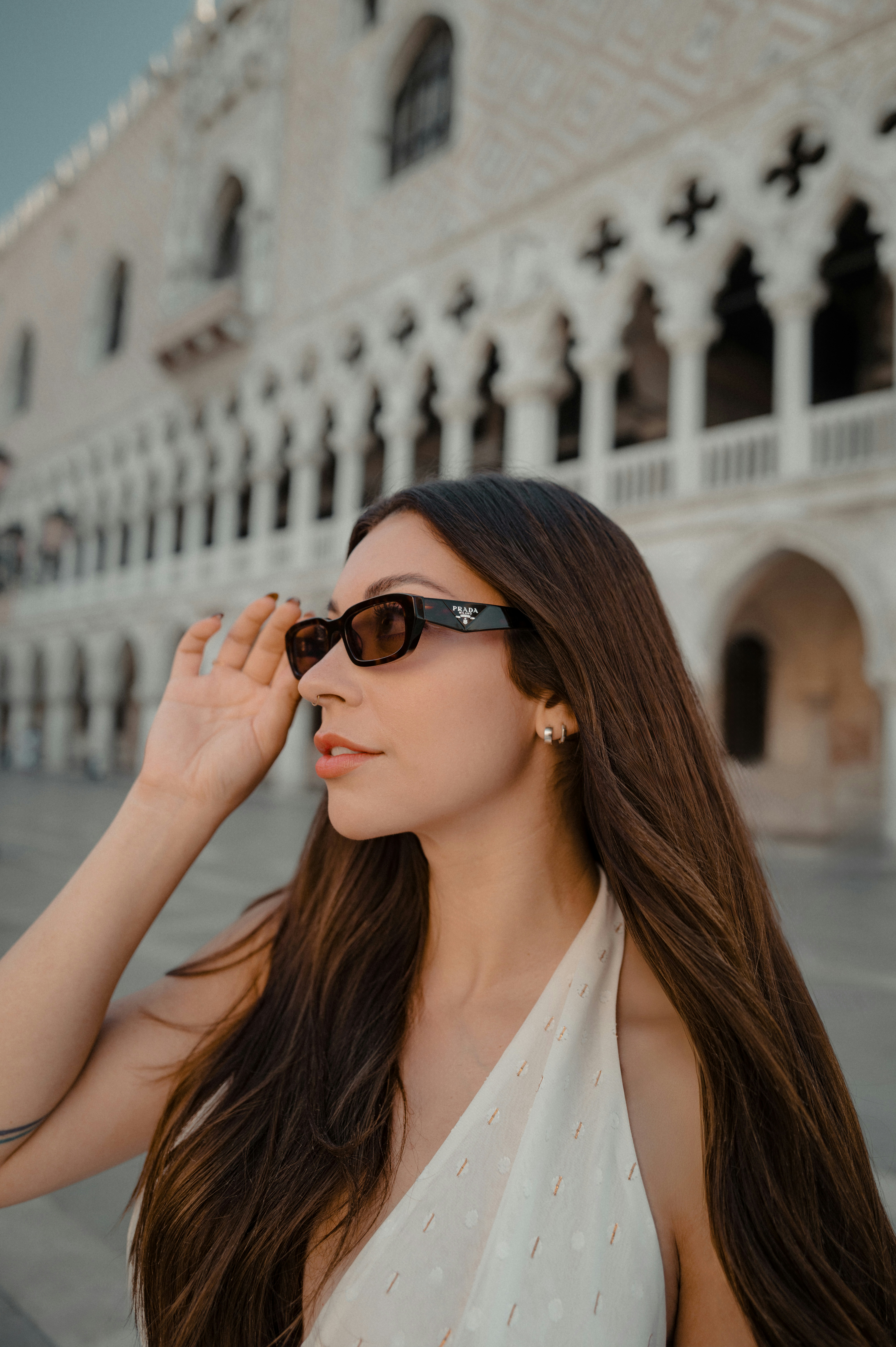 Mujer con gafas de sol frente a un edificio ornamentado