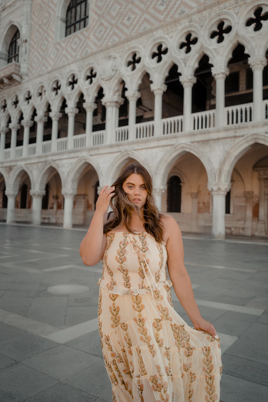 Model in a cream embroidered dress in a Venetian colonnade