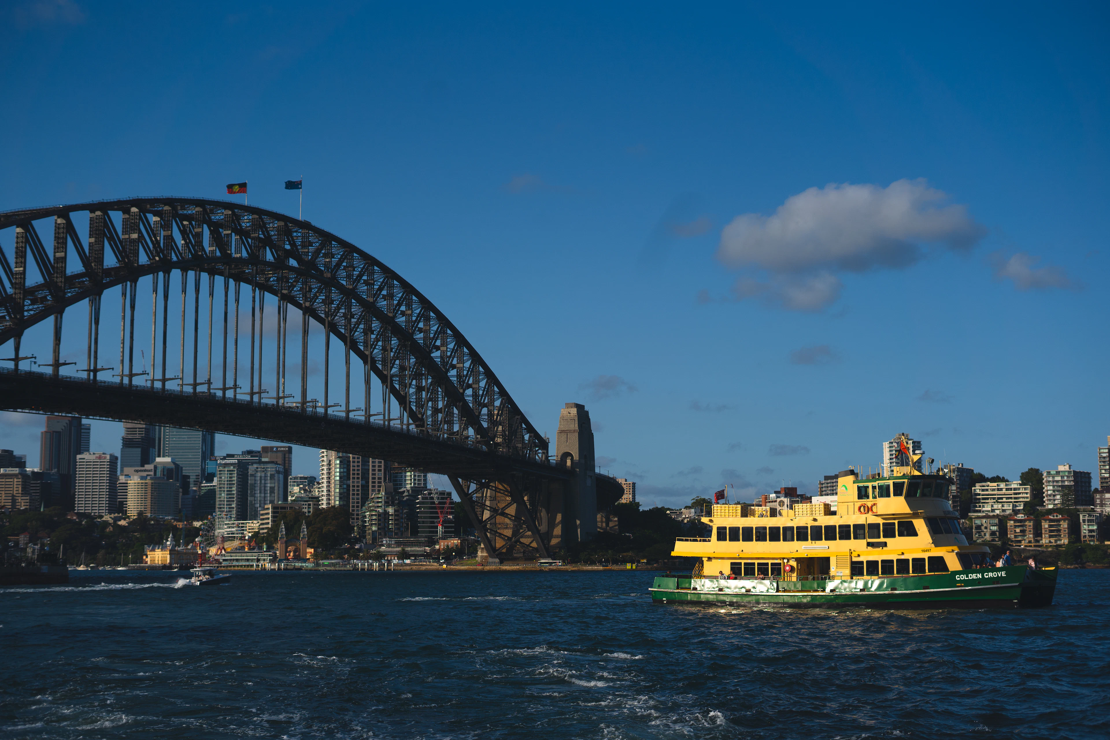 A yellow ferry passes the Sydney Harbour Bridge
