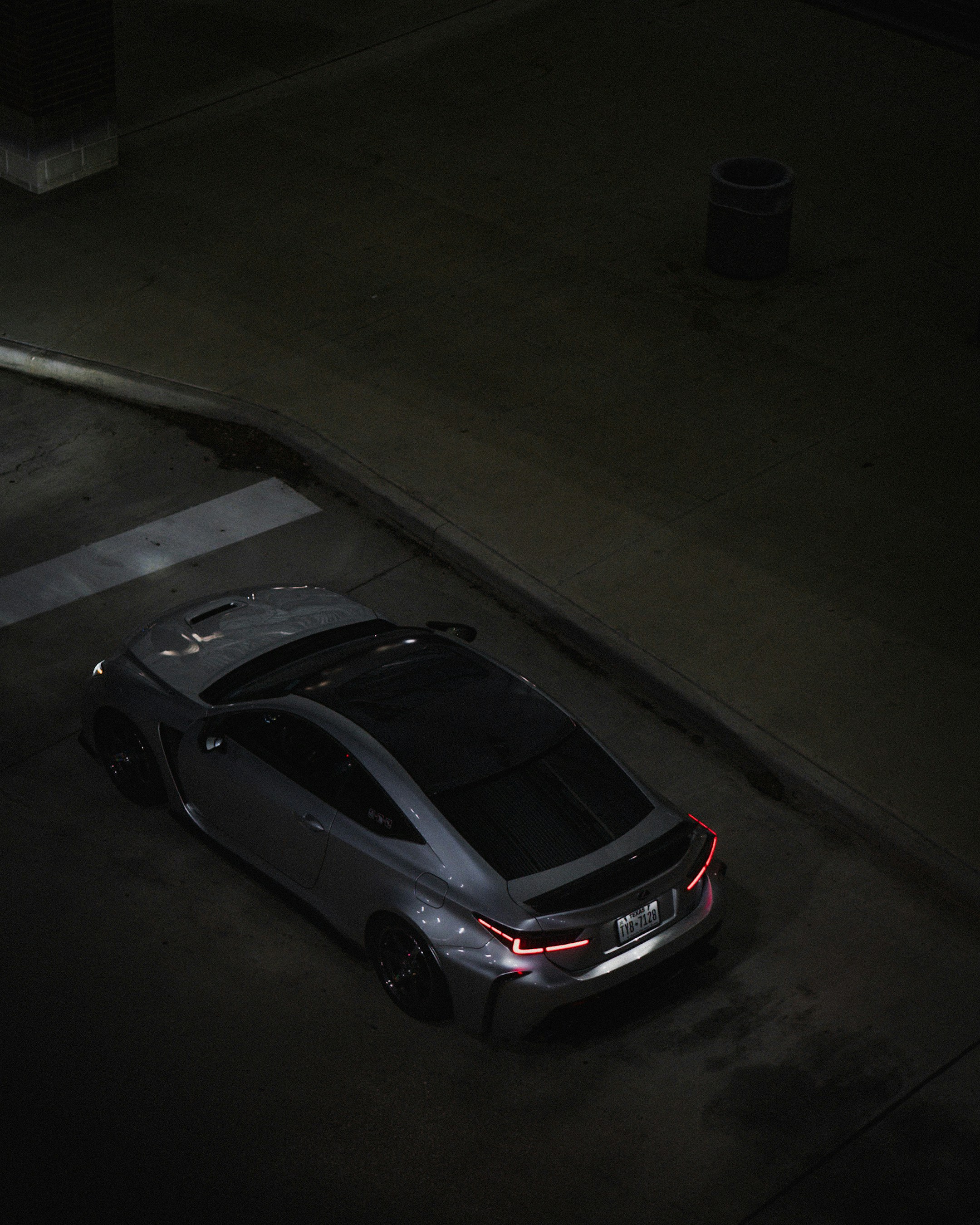 A sleek grey coupe parked on a dark street.