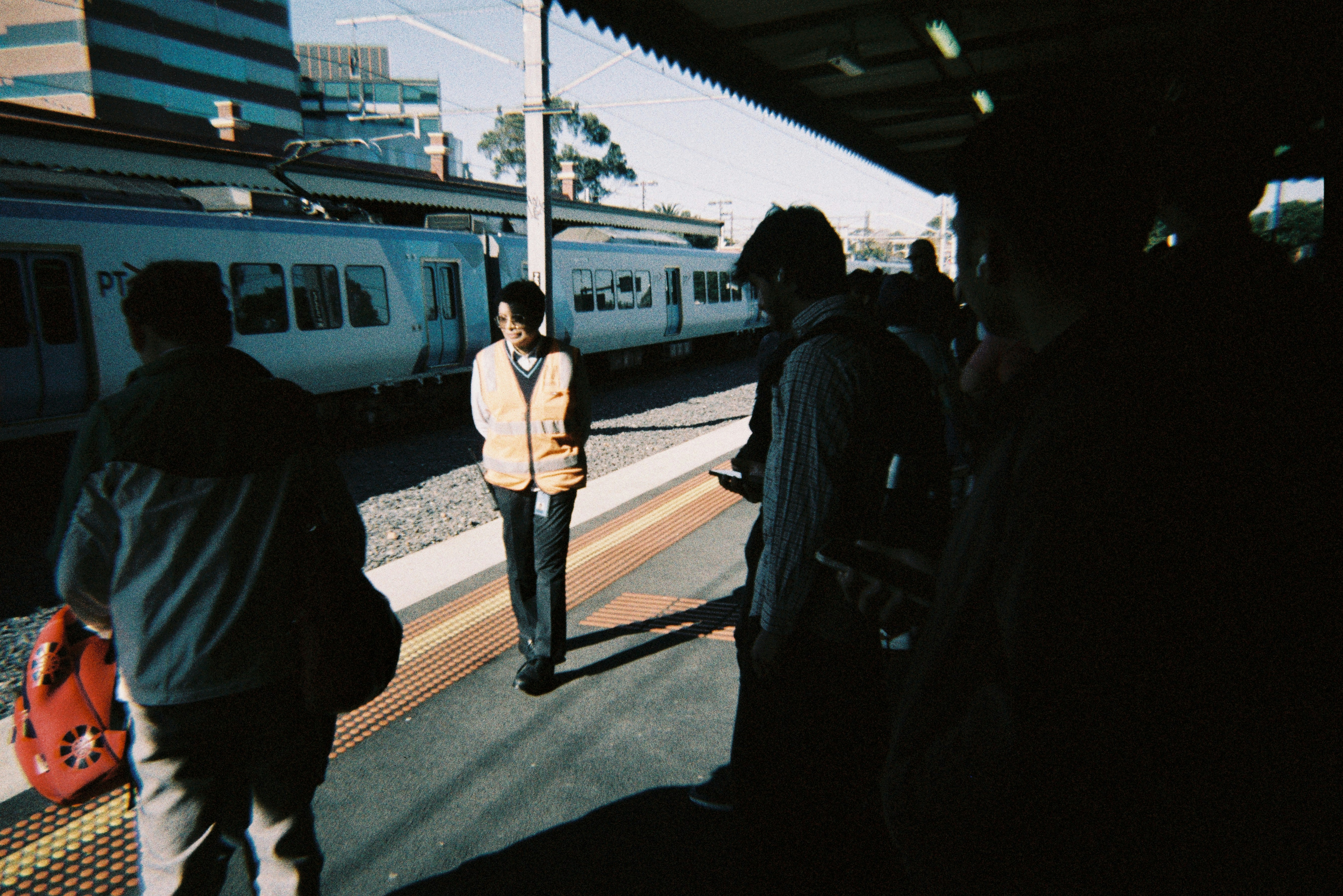 People waiting on a train platform with a train arriving.