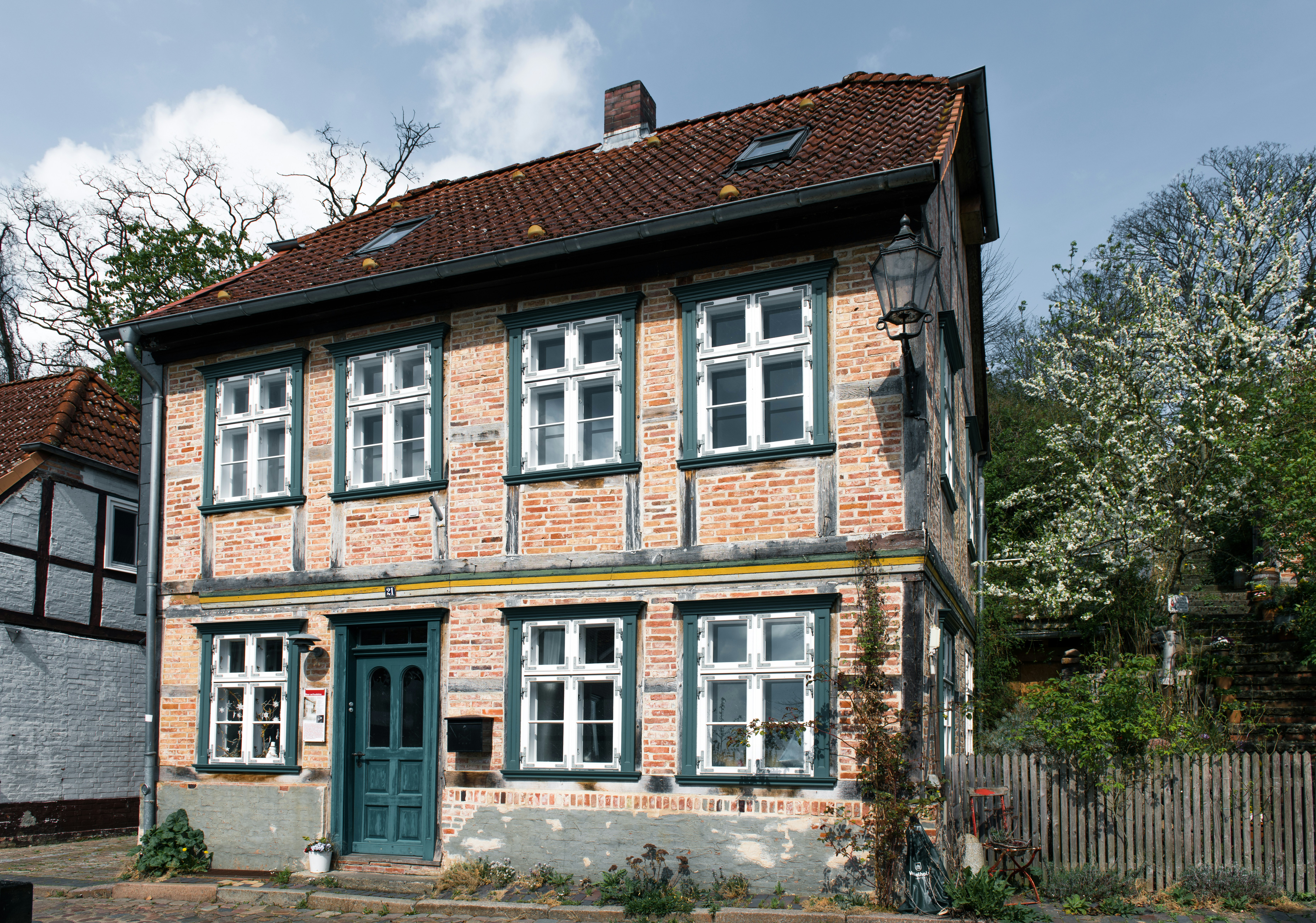 Old timber-framed house with green door and windows.