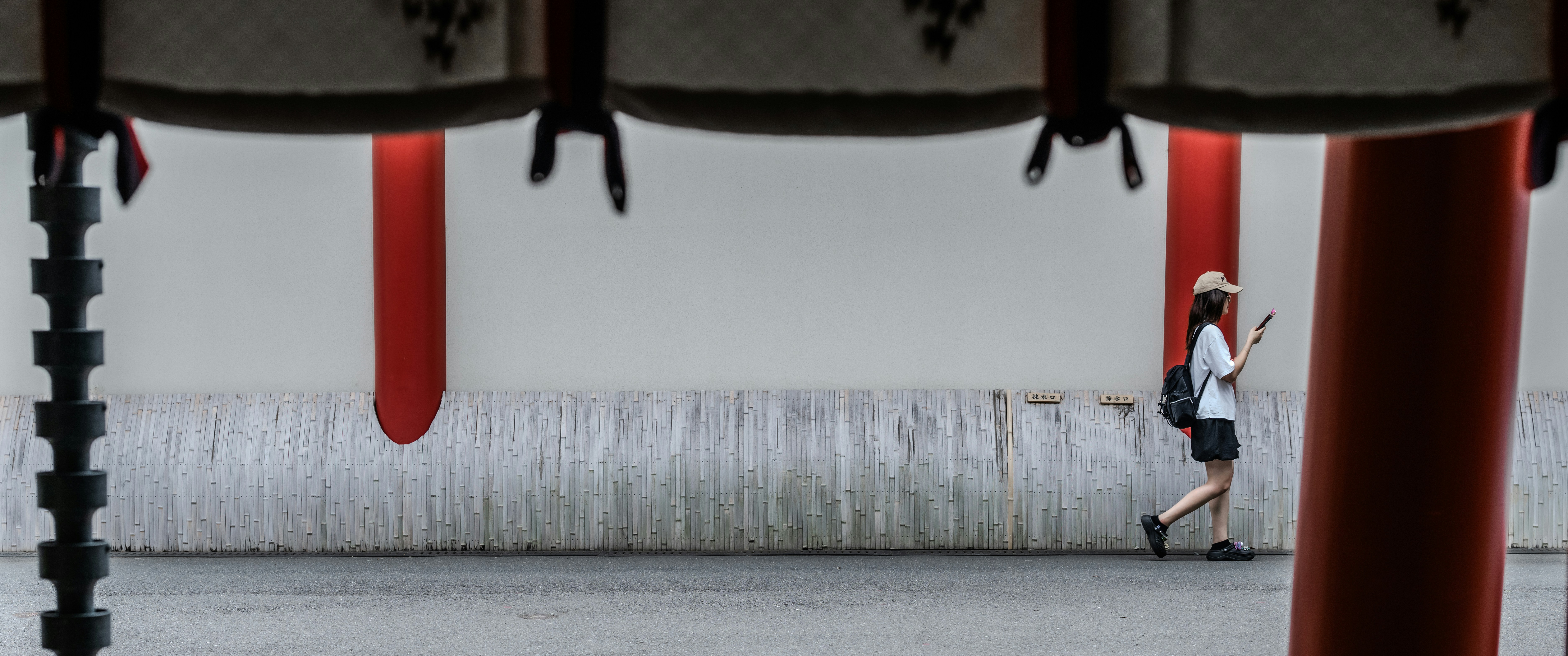 Woman walking with a backpack and phone