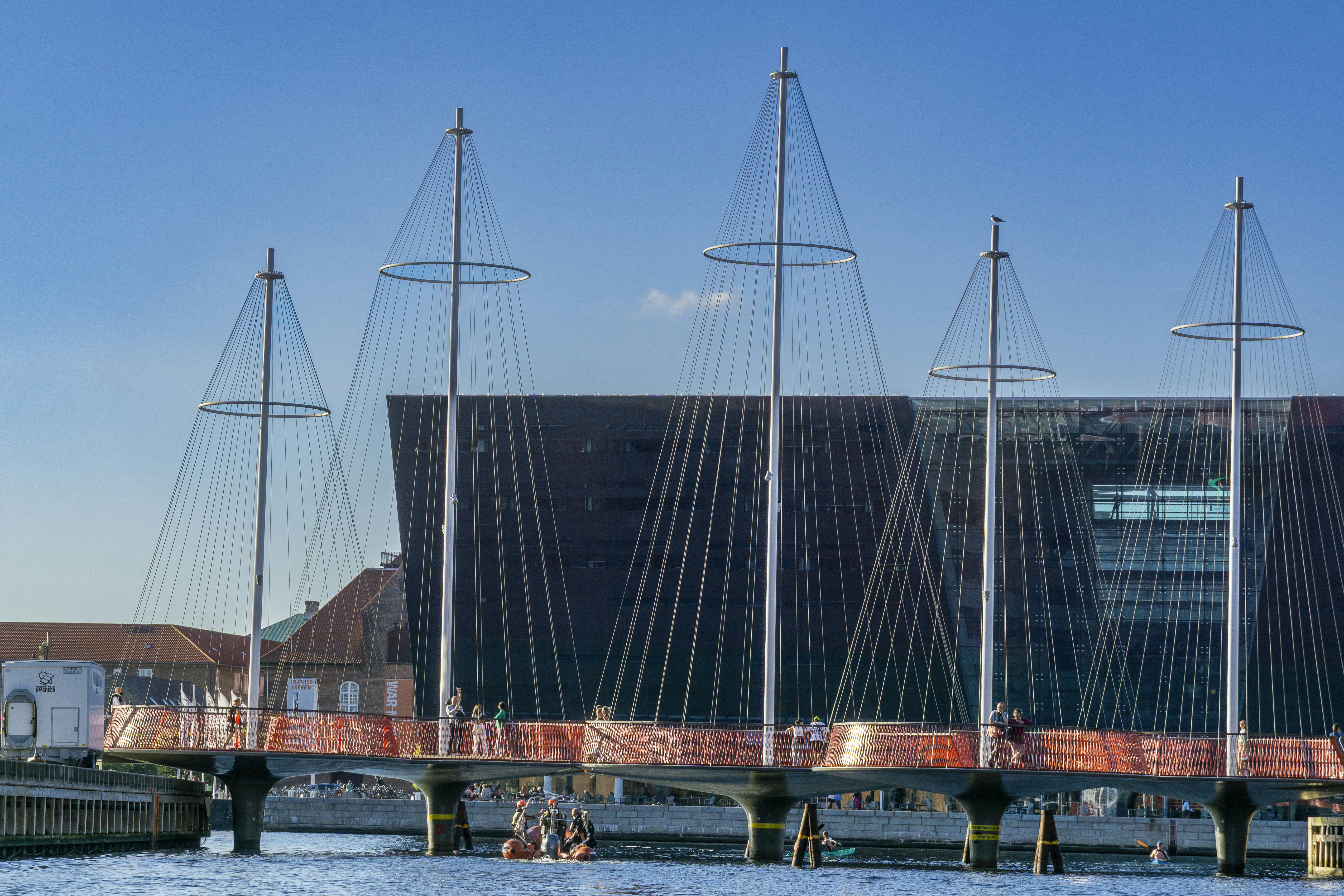 Modern bridge with distinctive sail-like masts over water.