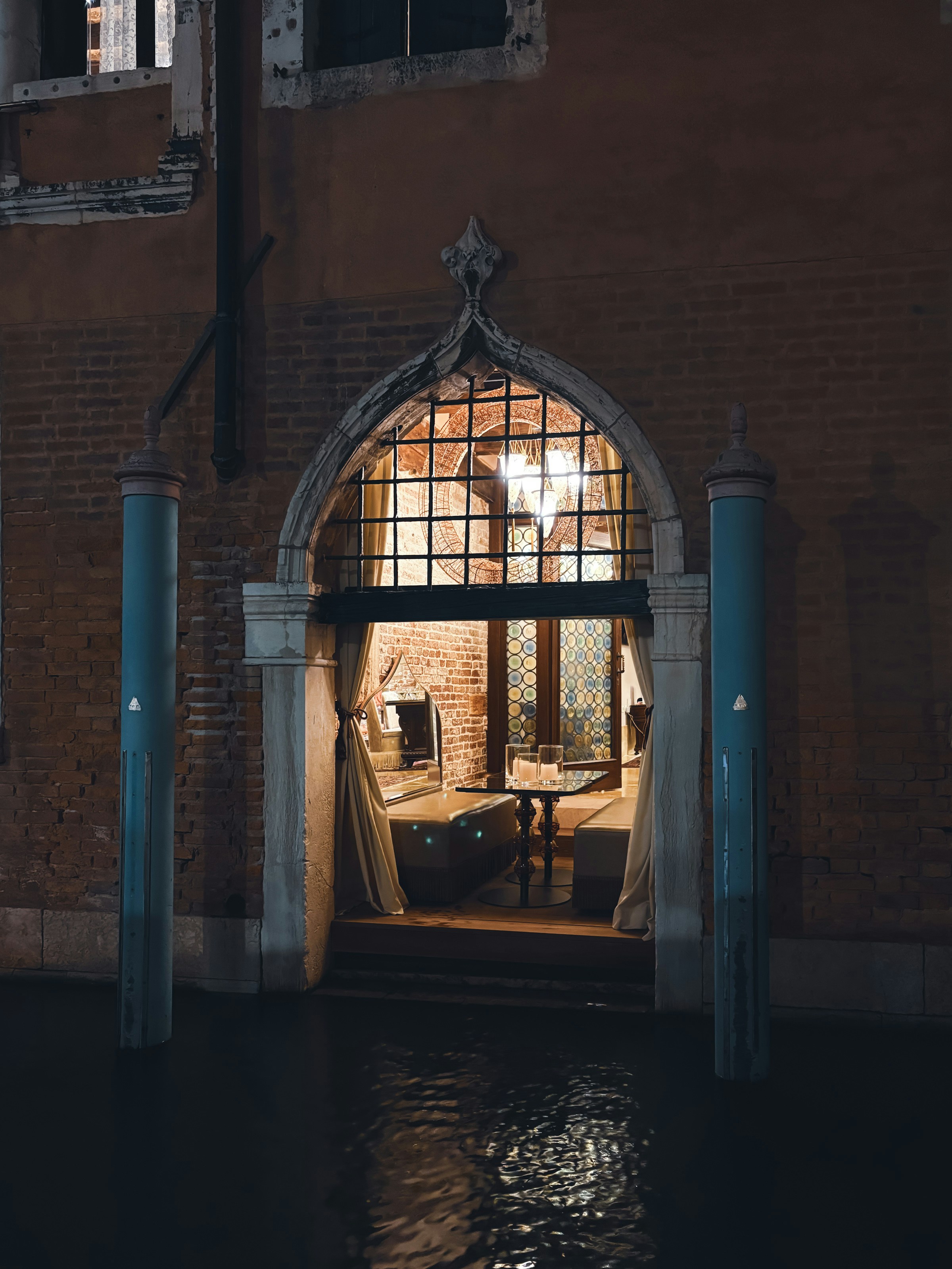 An ornate arched doorway opens to a dimly lit room.
