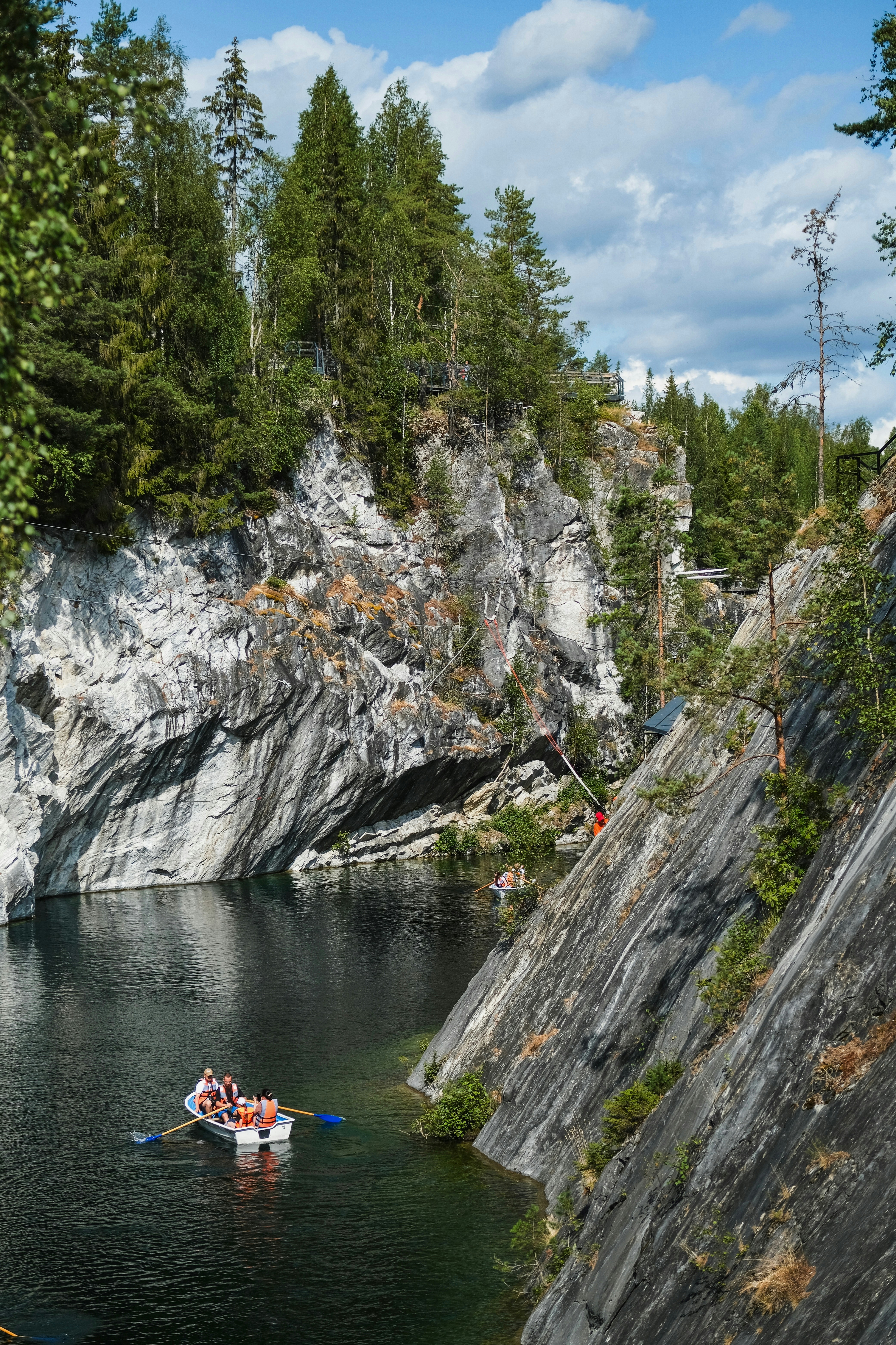 People in a boat on a lake surrounded by cliffs.