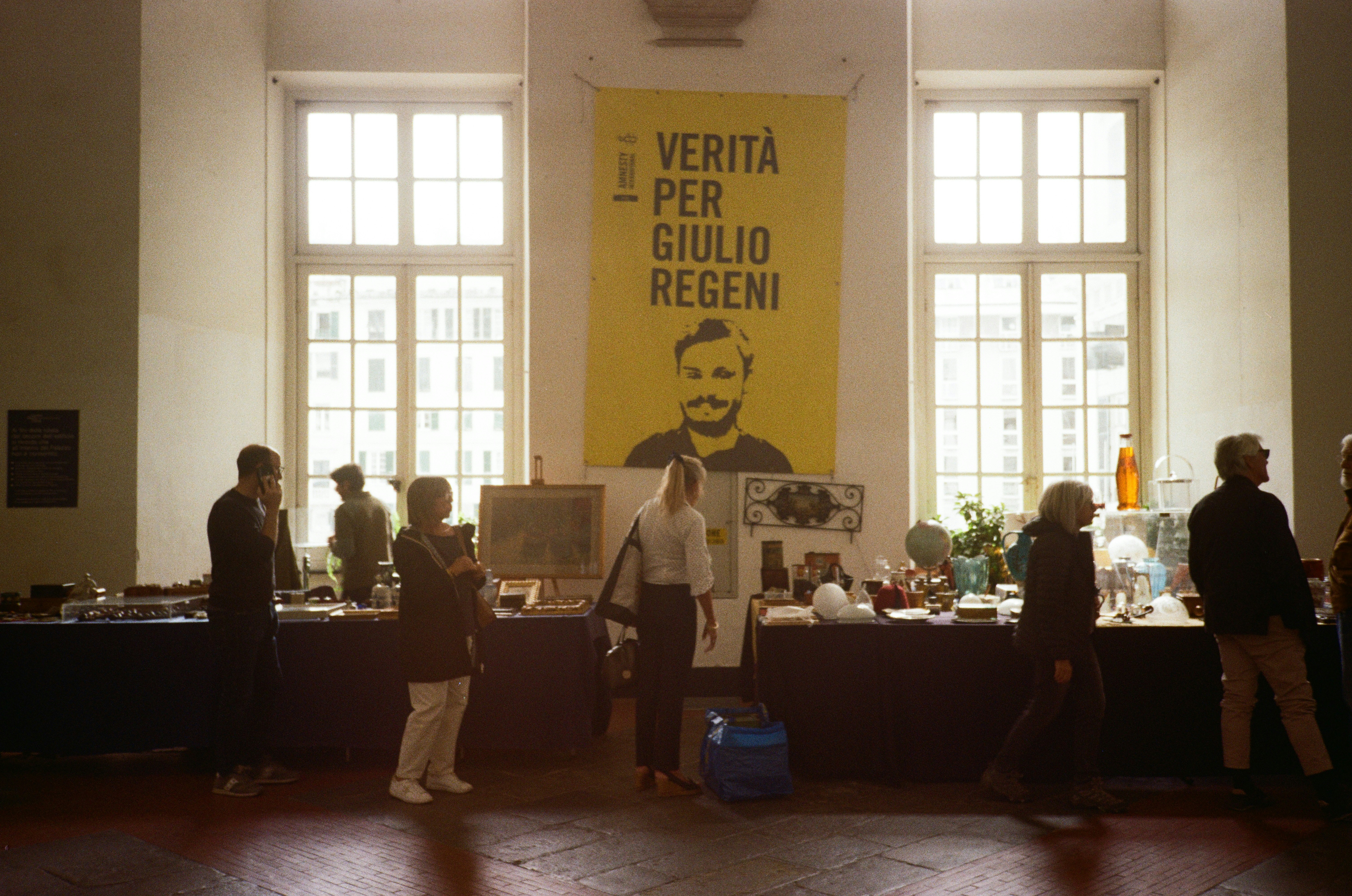 People gathered at tables with a banner in background.