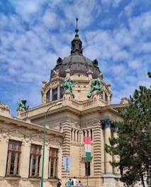 Ornate building with a dome and statues under blue sky