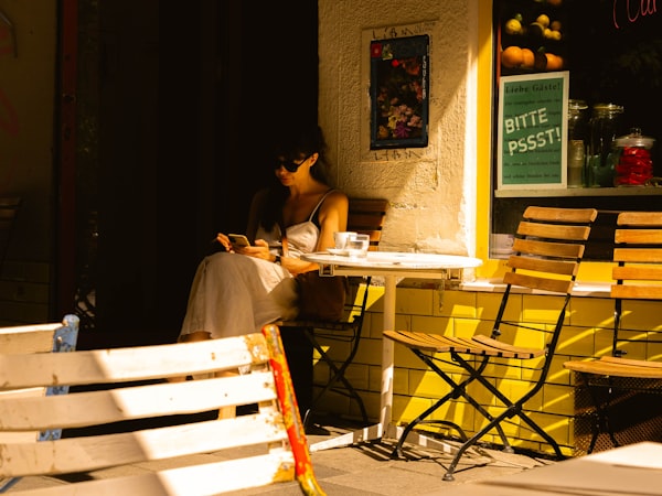 Woman at a cafe table using a phone