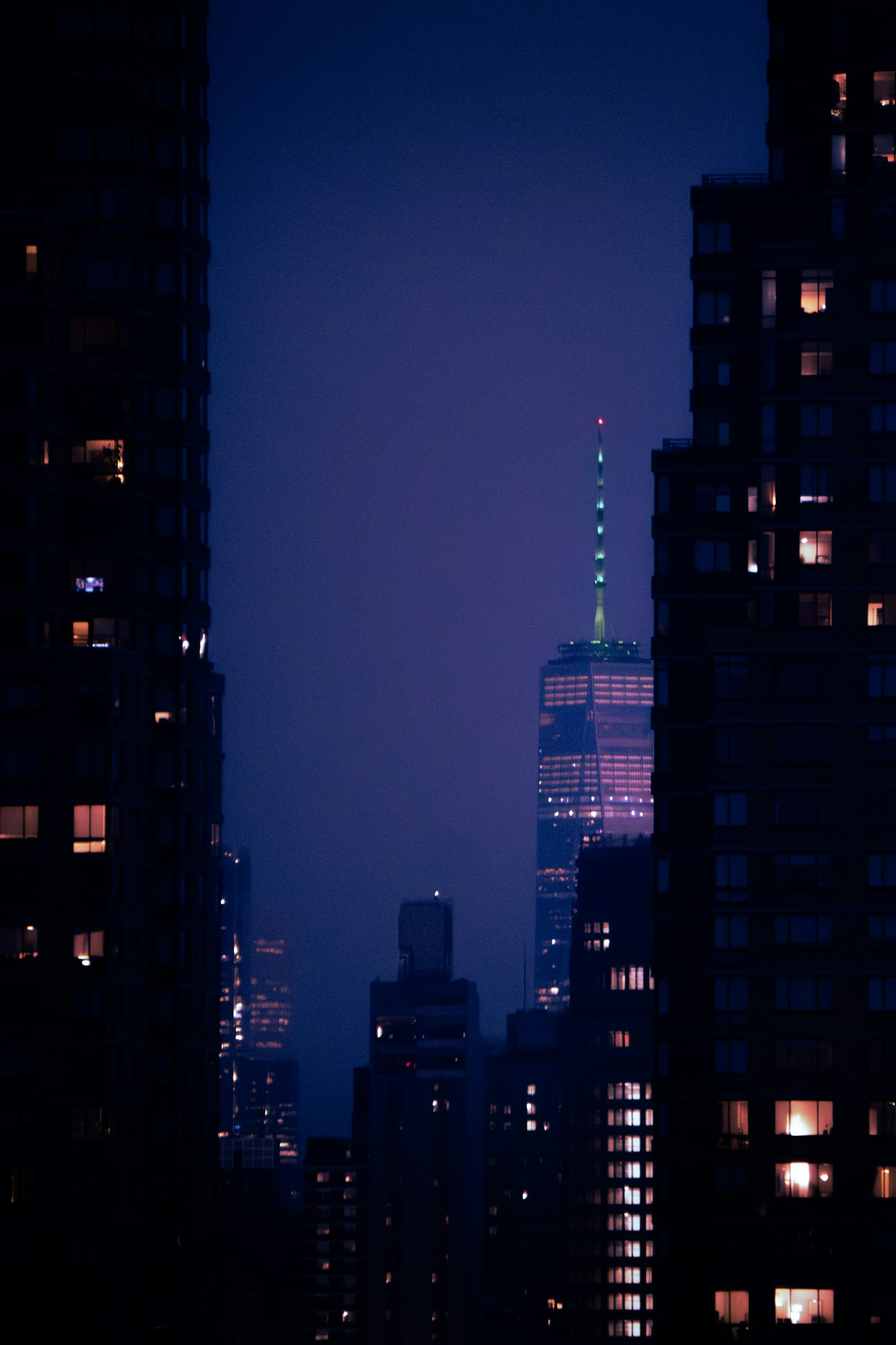 Skyscrapers illuminated against a dark night sky.
