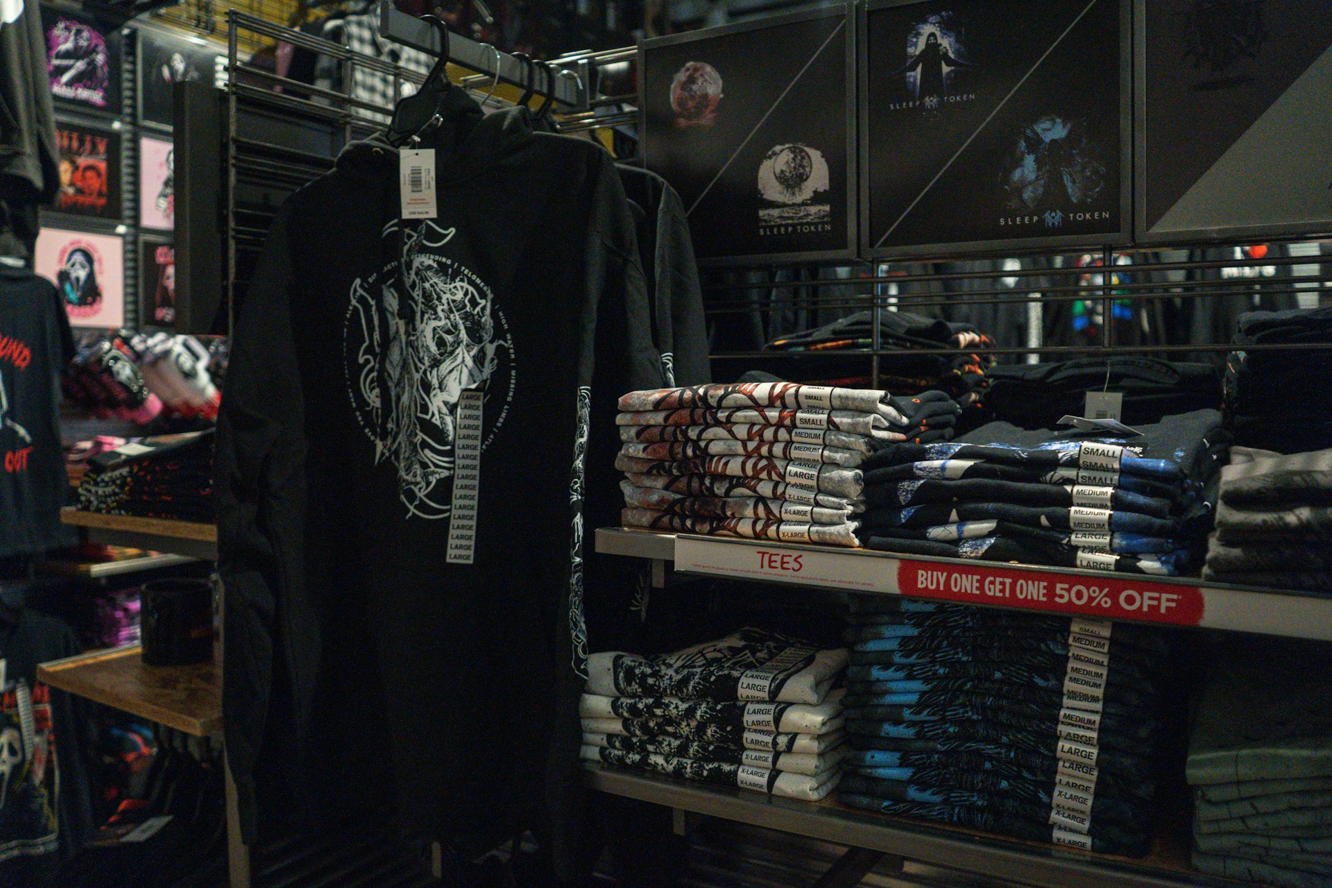 Black t-shirts with graphic designs displayed in store.