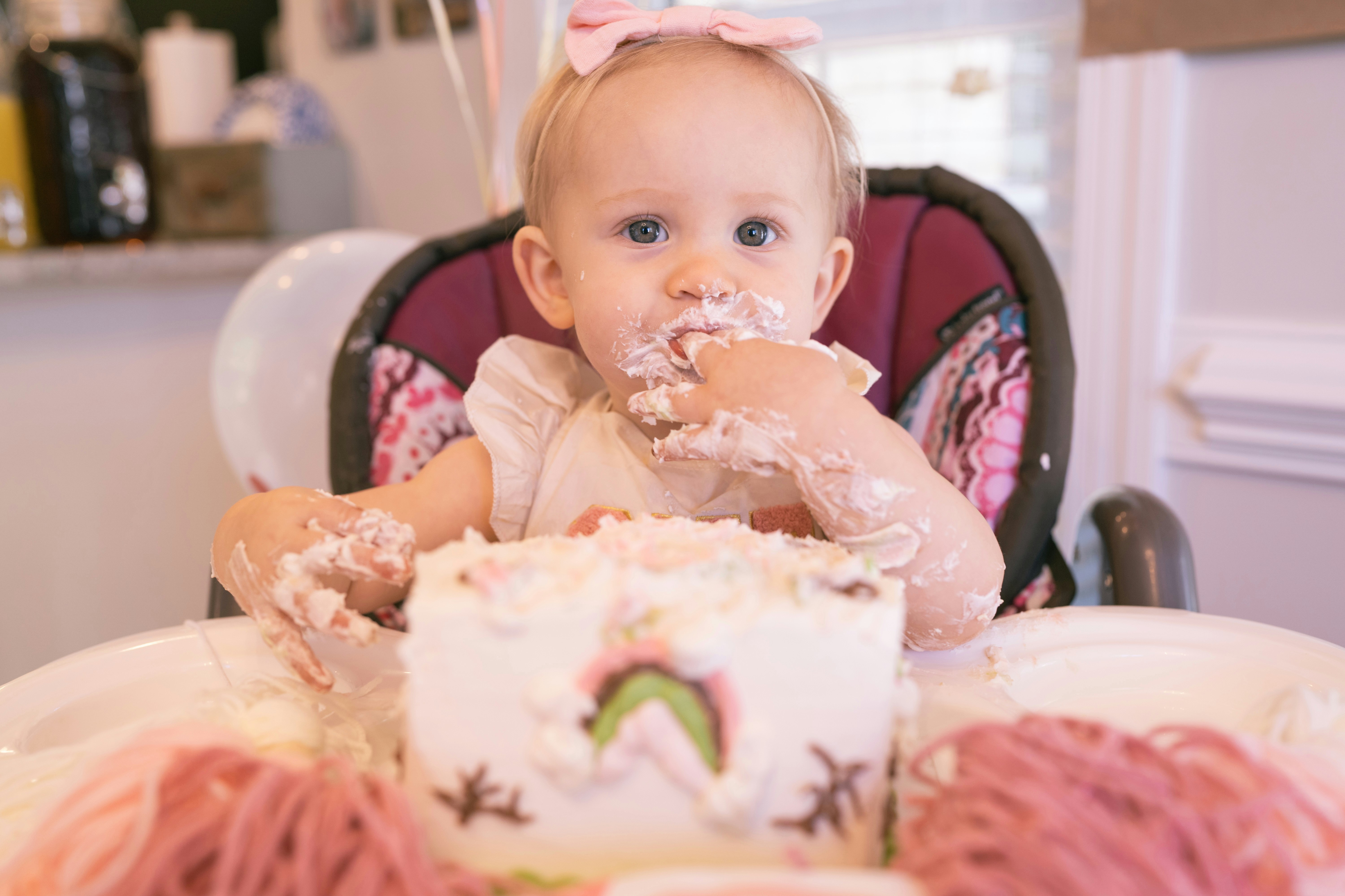 Baby covered in cake at birthday celebration