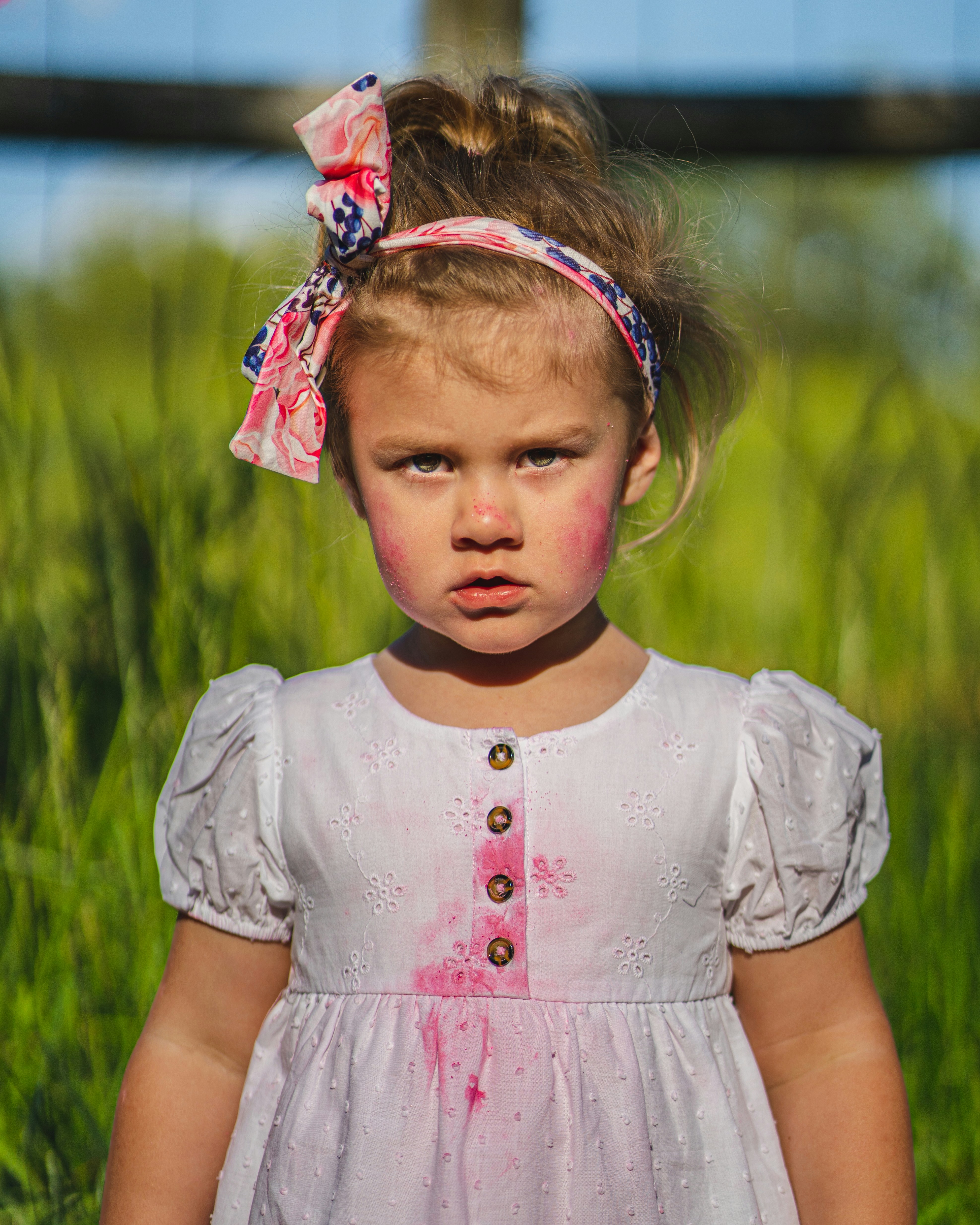Jeune fille avec tache rose sur robe blanche