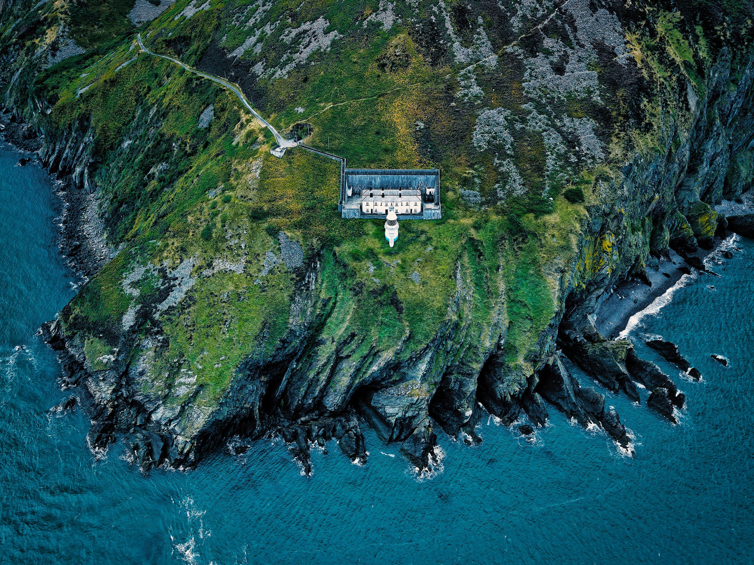 A remote stone holiday cottage on a green island, surrounded by sea