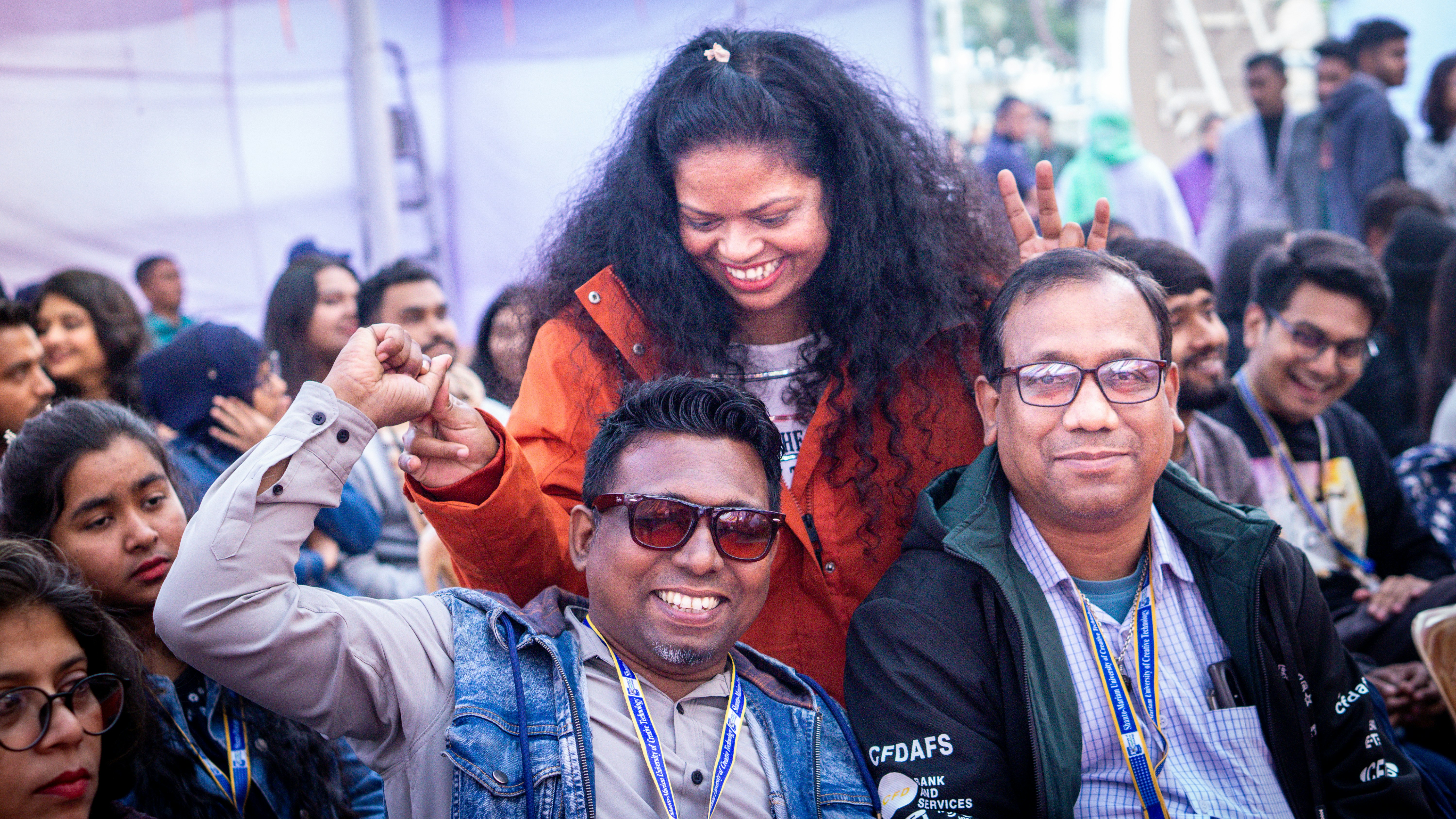 People gathered at an outdoor event, smiling and interacting.