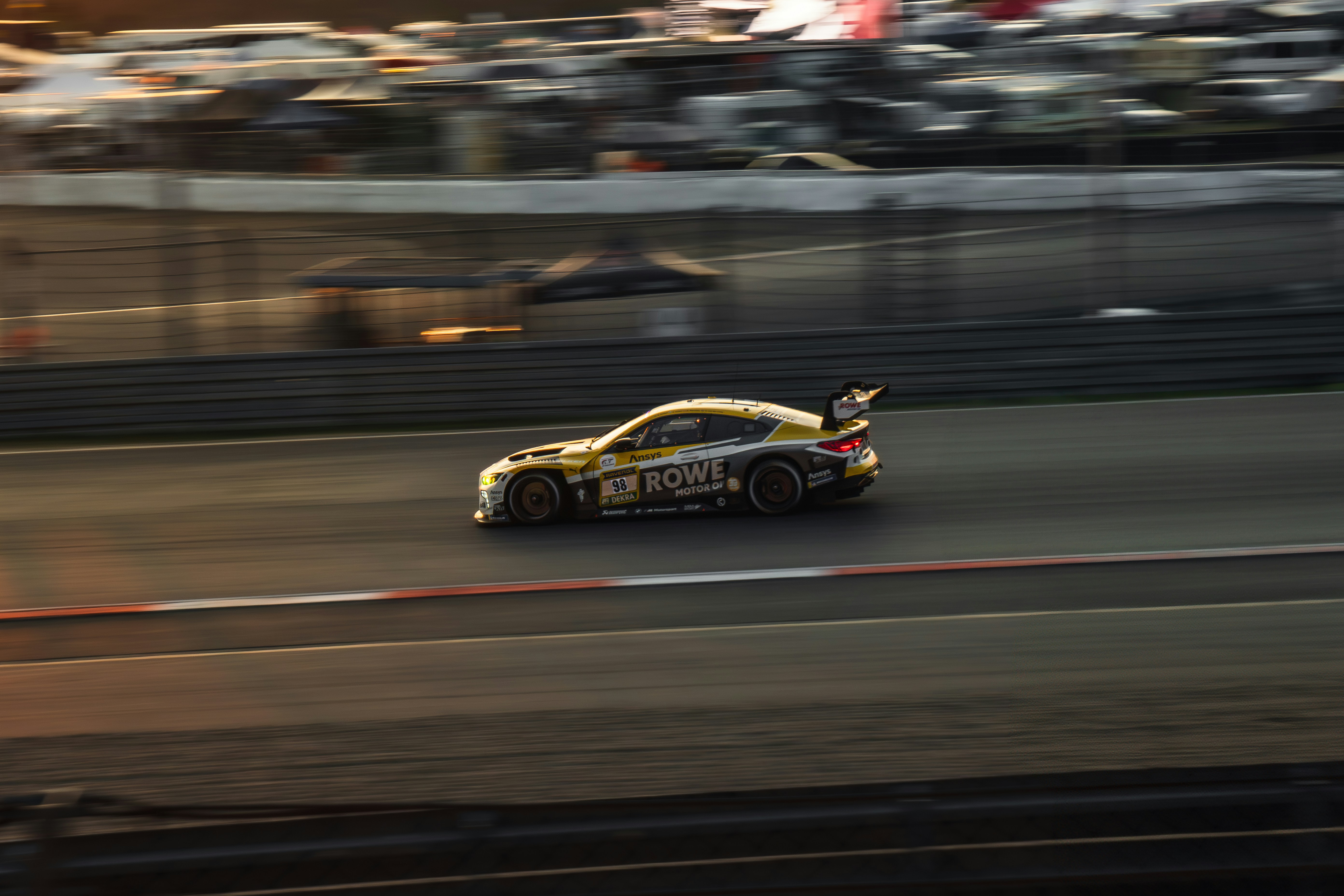 Race car speeding on a track during sunset
