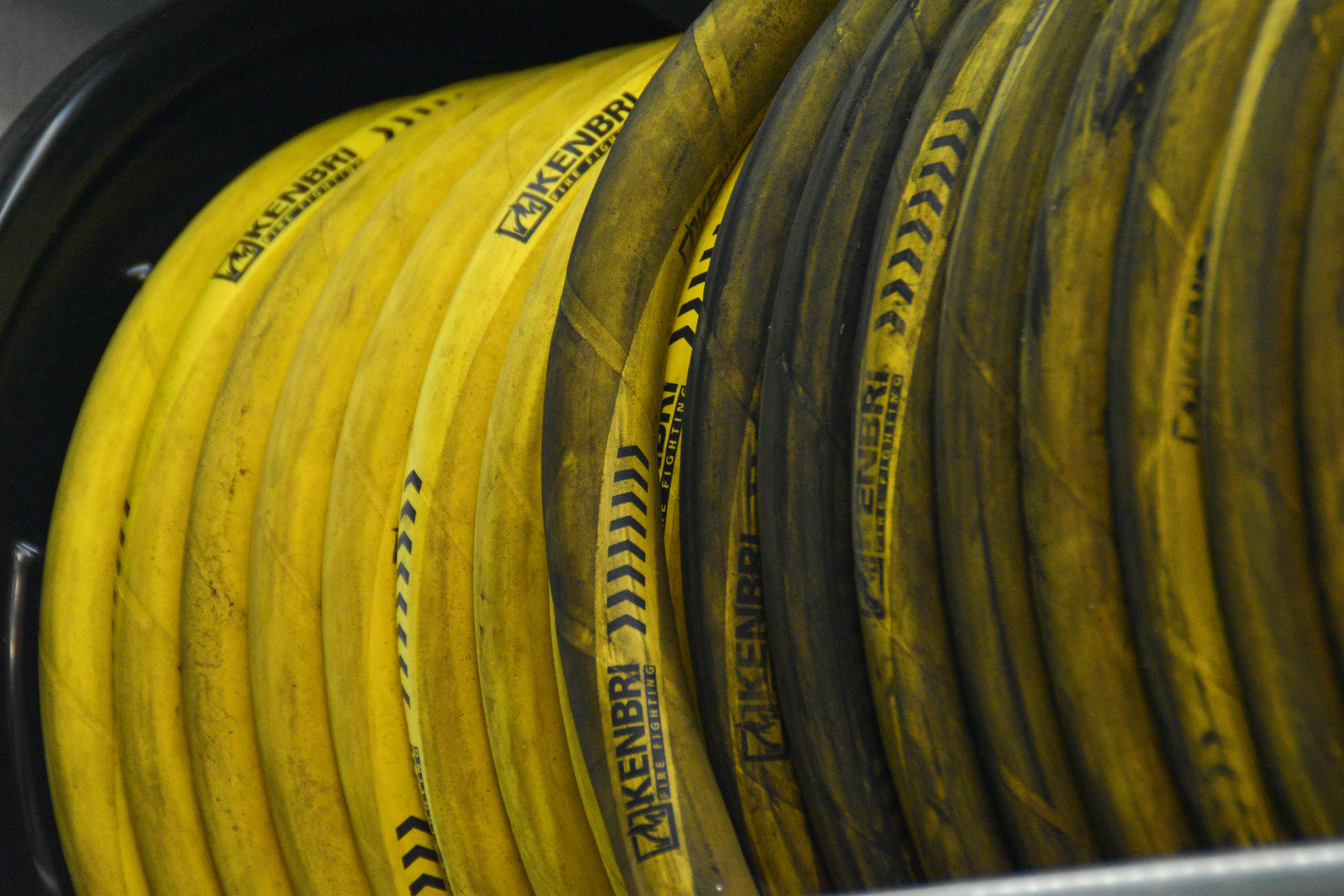 Yellow hoses coiled on a black reel
