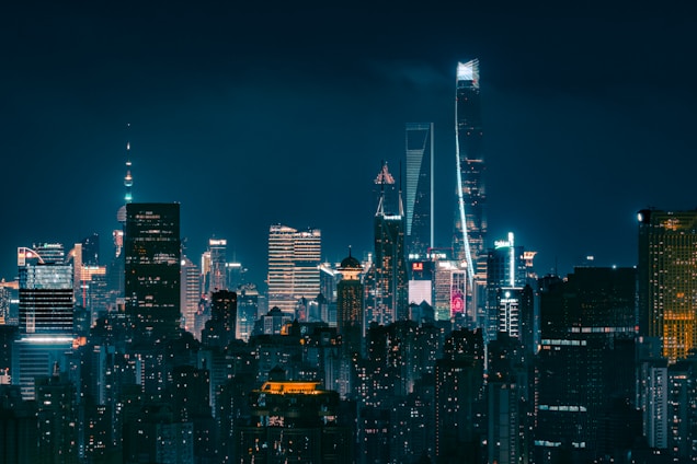 Skyscrapers illuminated at night in a sprawling cityscape.