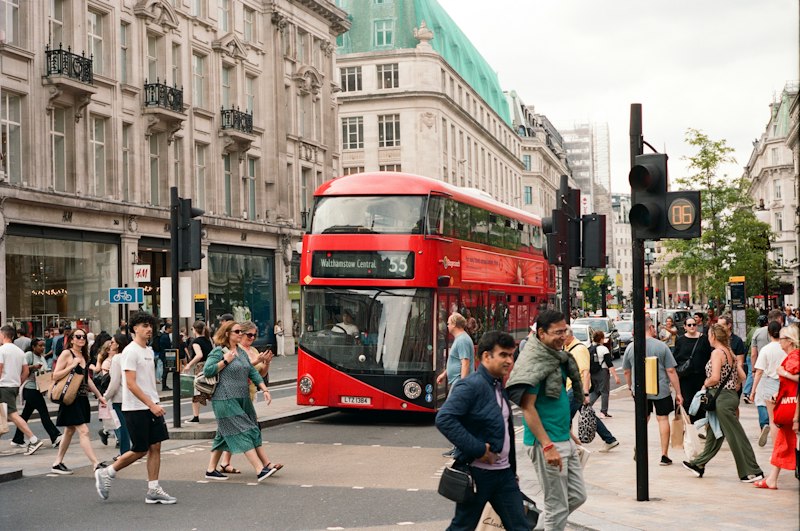 Red double-decker bus on a busy city street.