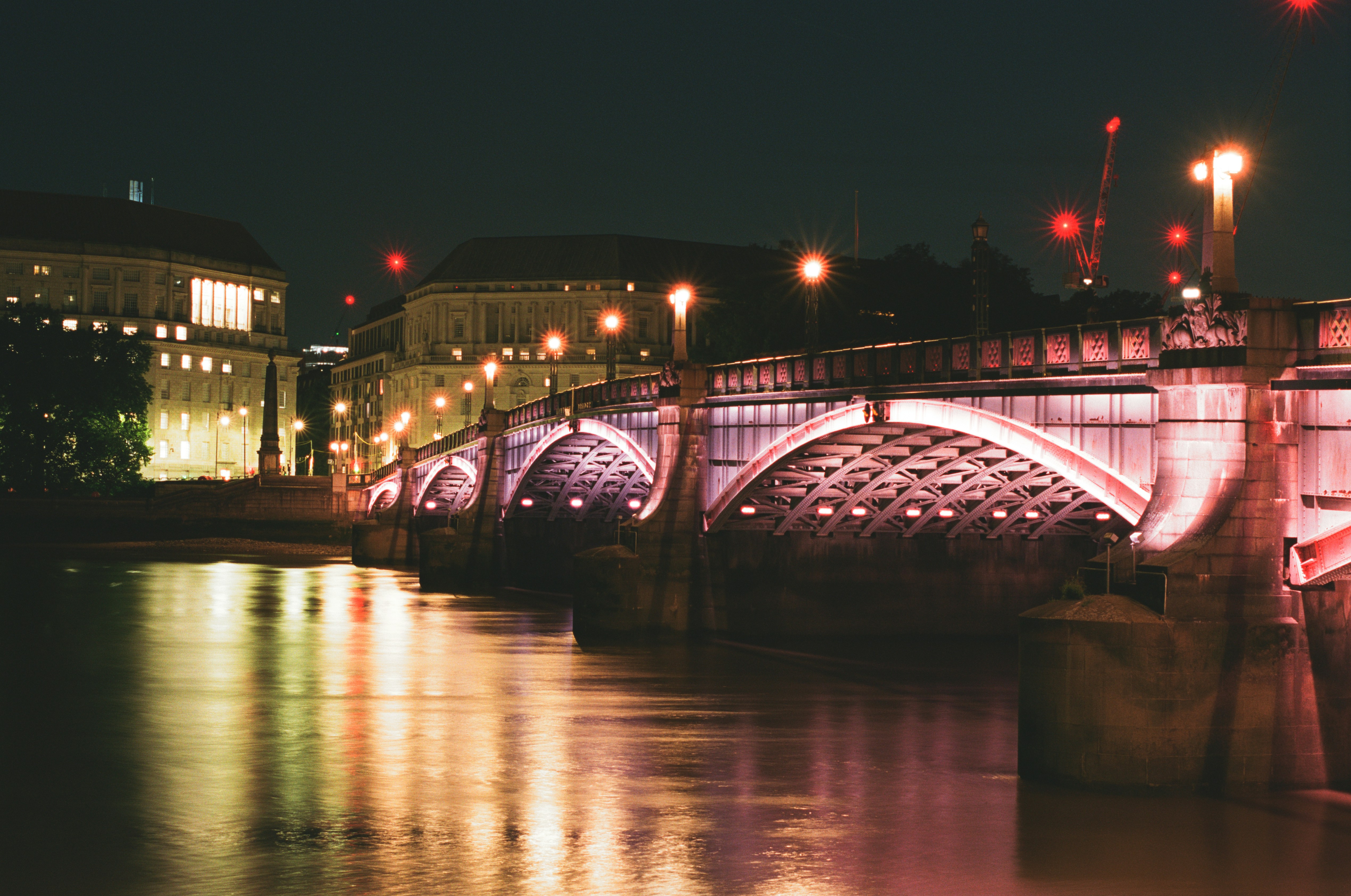 Illuminated bridge over water at night