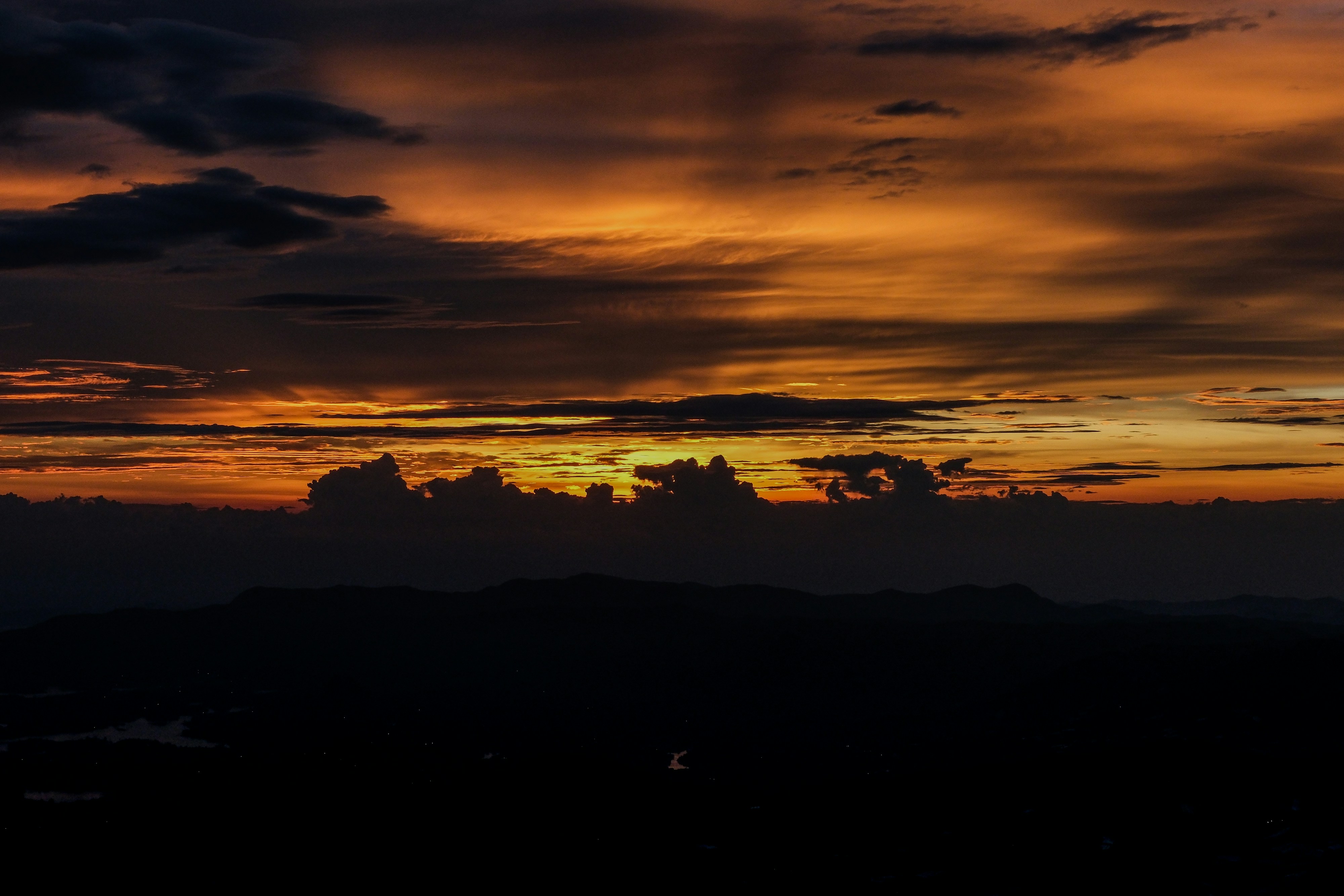 Dramatic sunset sky over dark mountain silhouette