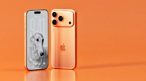 Two rose gold iphones on an orange background