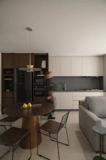 Modern kitchen and dining area with person walking