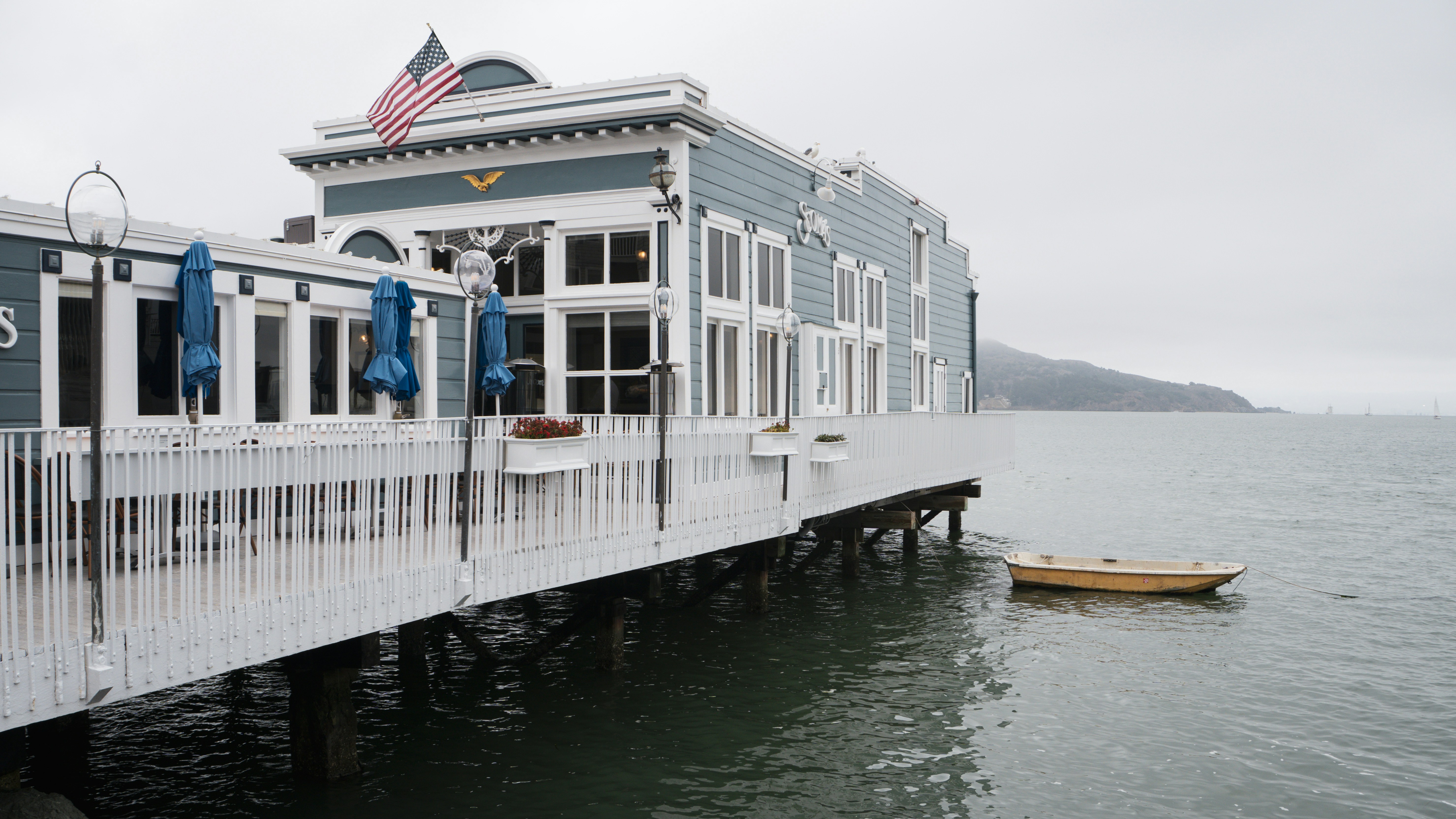 Building on pier with rowboat on a cloudy day