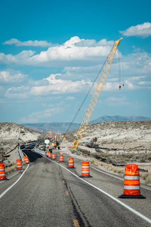 Road construction with crane and orange barrels