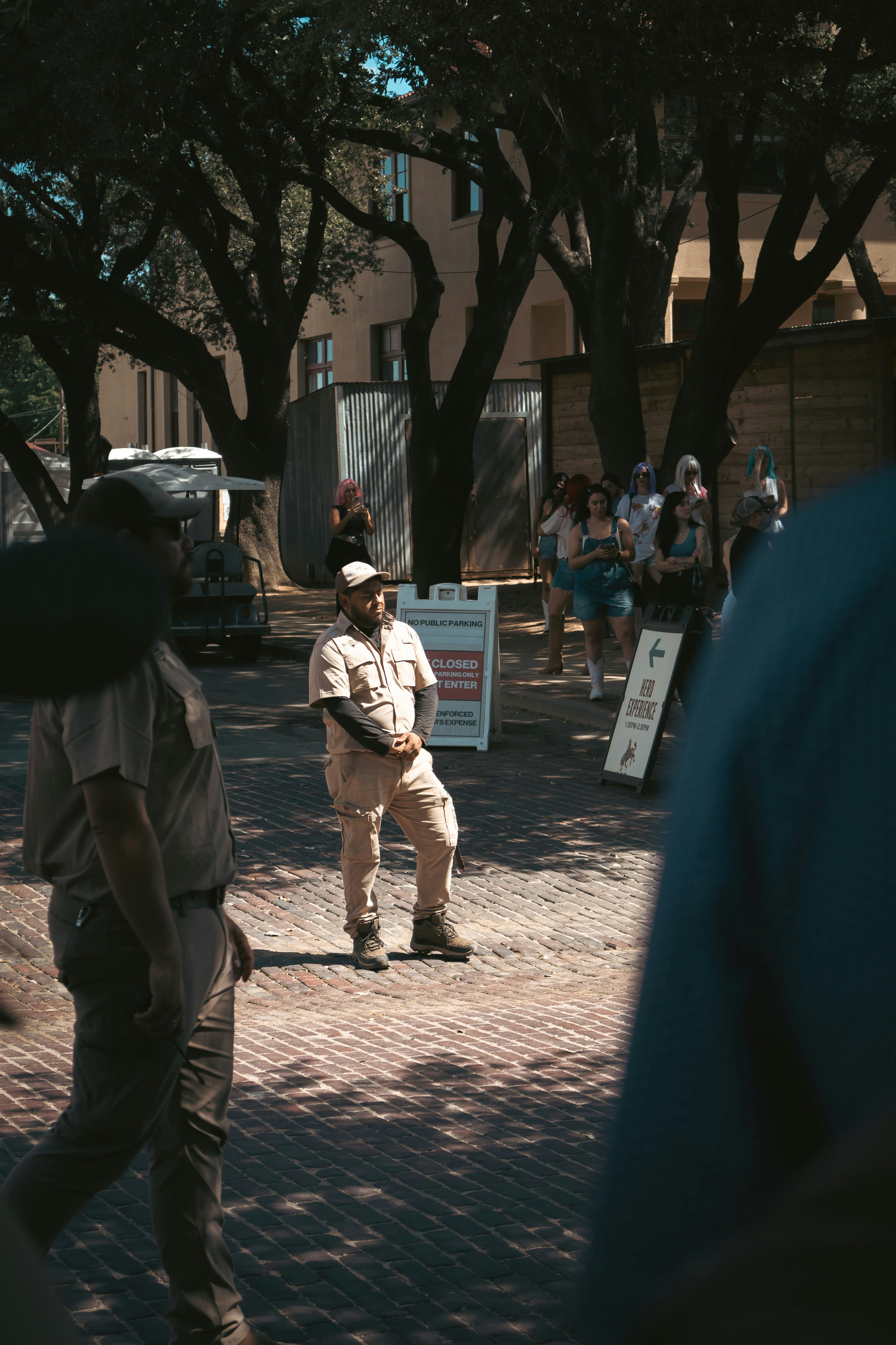 Man in uniform standing outdoors with people in background