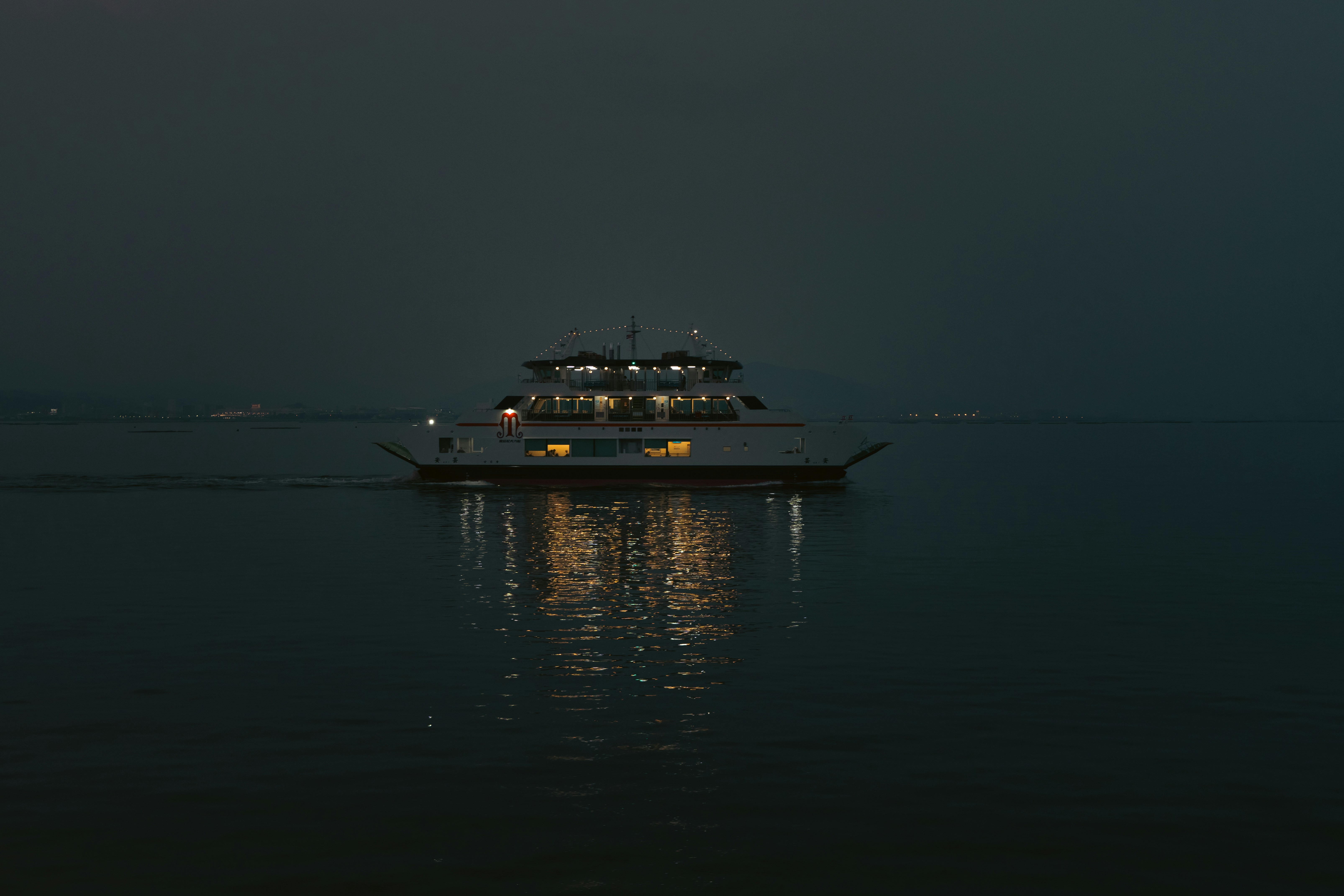 Ferry boat illuminated at night on calm water