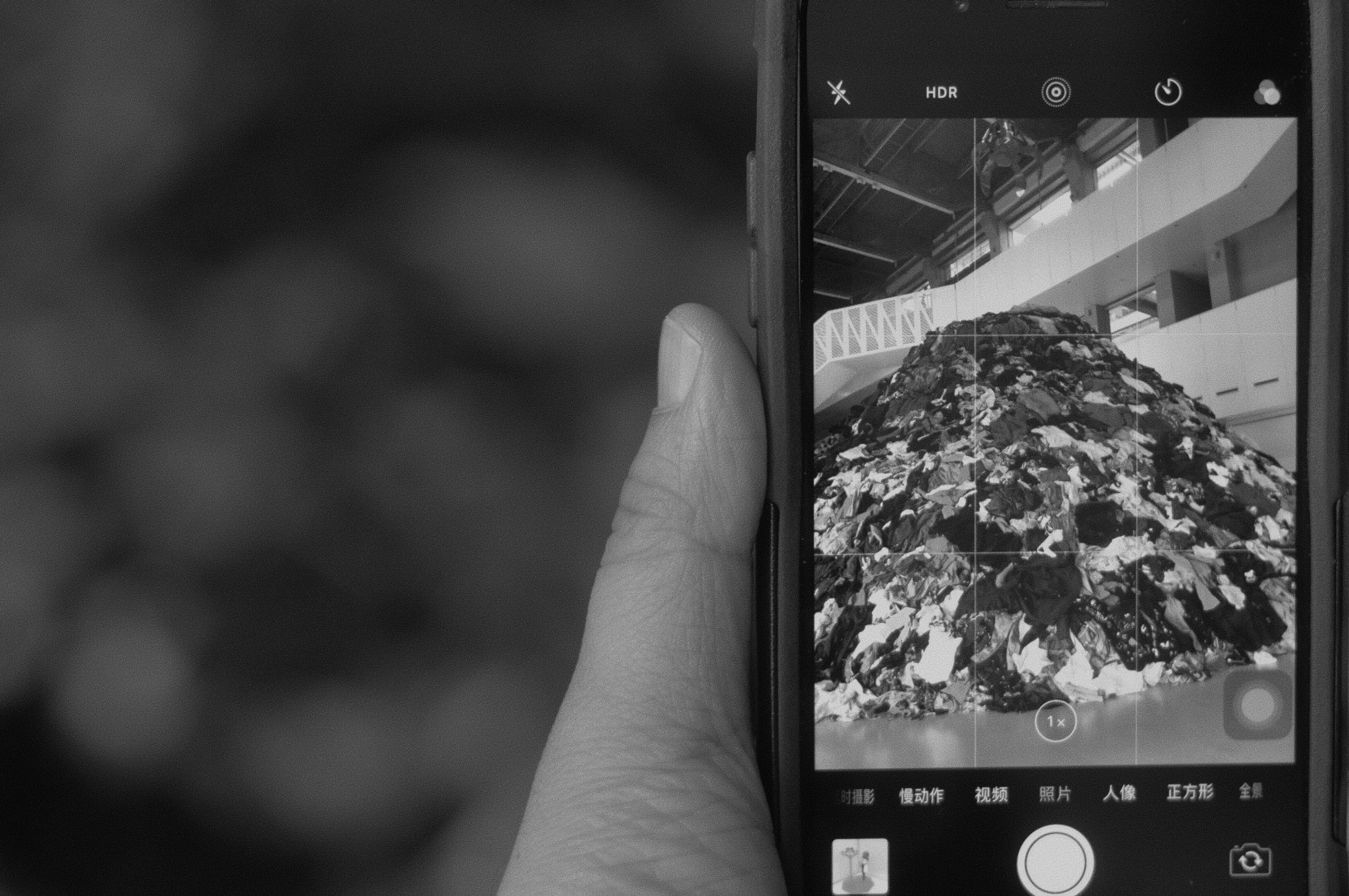 Smartphone capturing abstract art installation in black and white