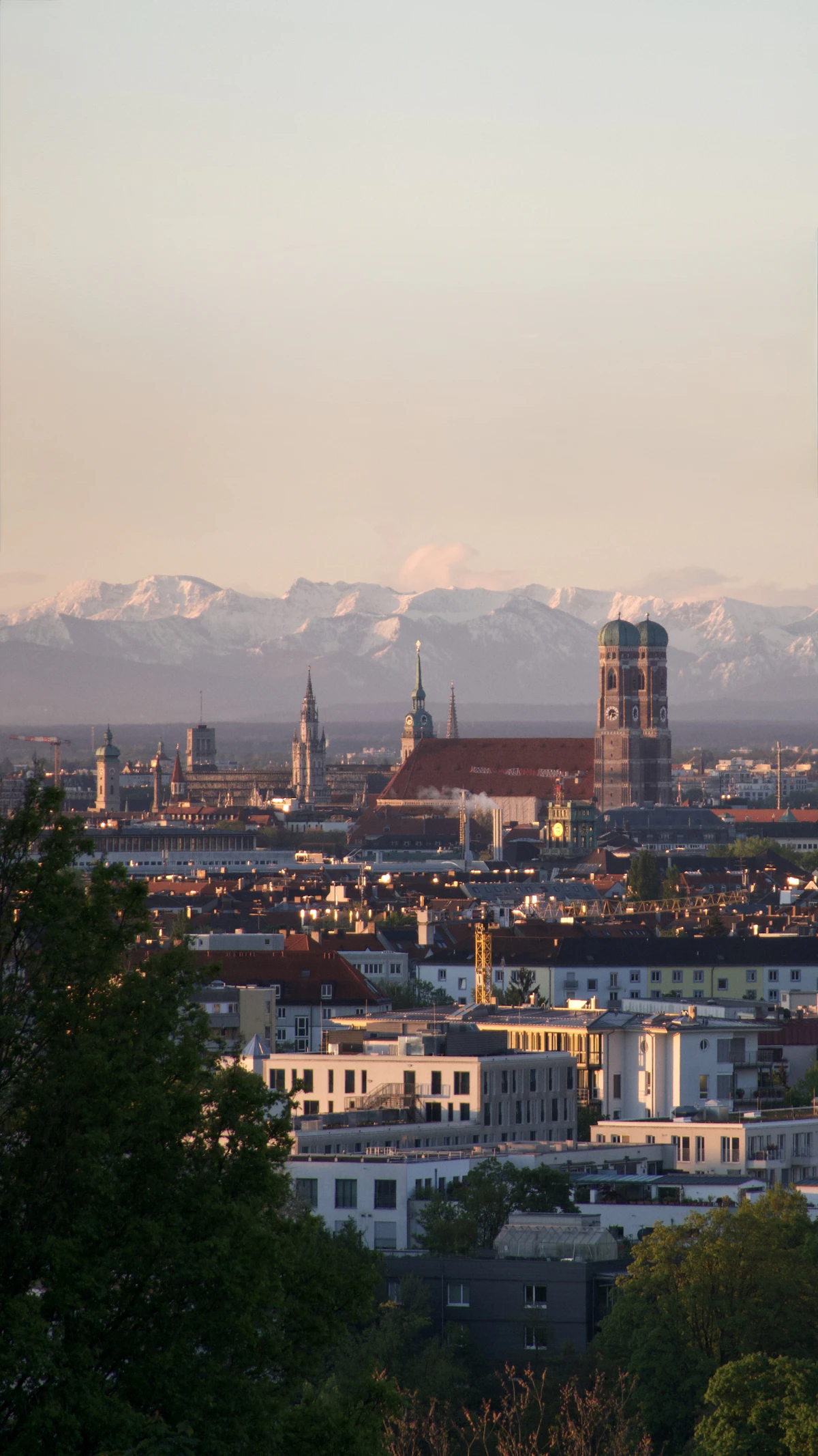Blick vom Olympiaberg auf München mit den Alpen im Hintergrund
