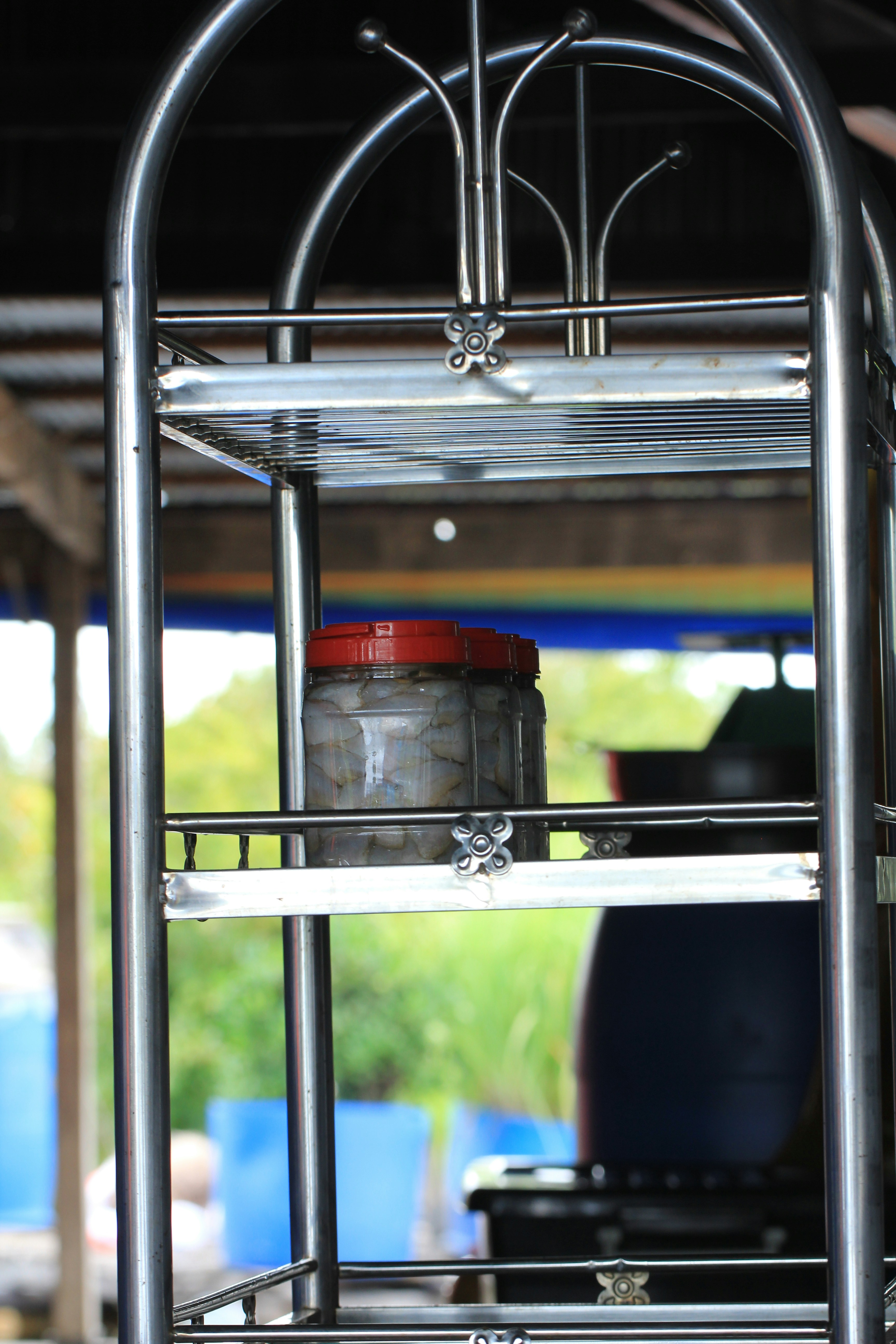 Jar with red lid on metal shelf