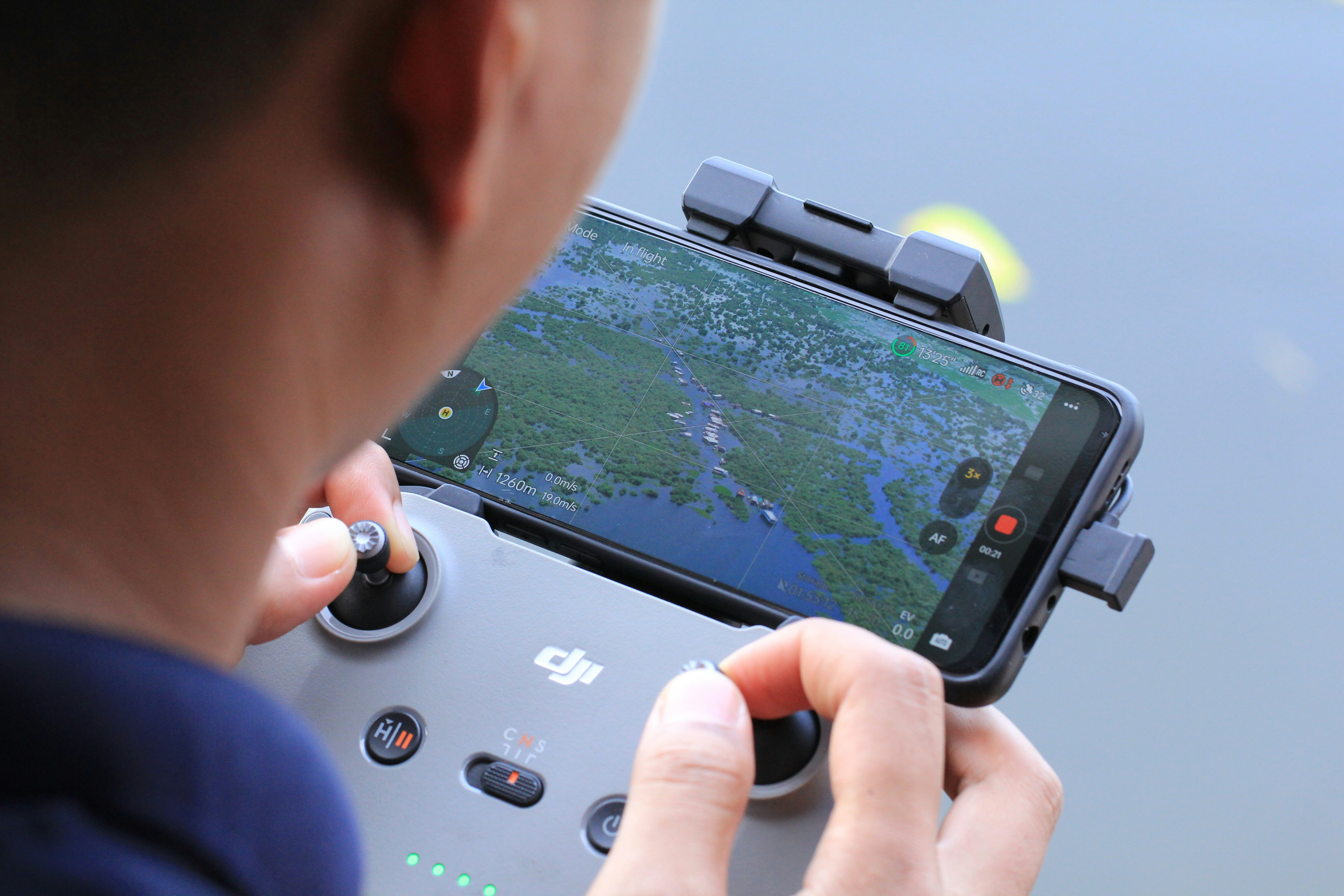 Persona que controla el dron con teléfono inteligente y controlador