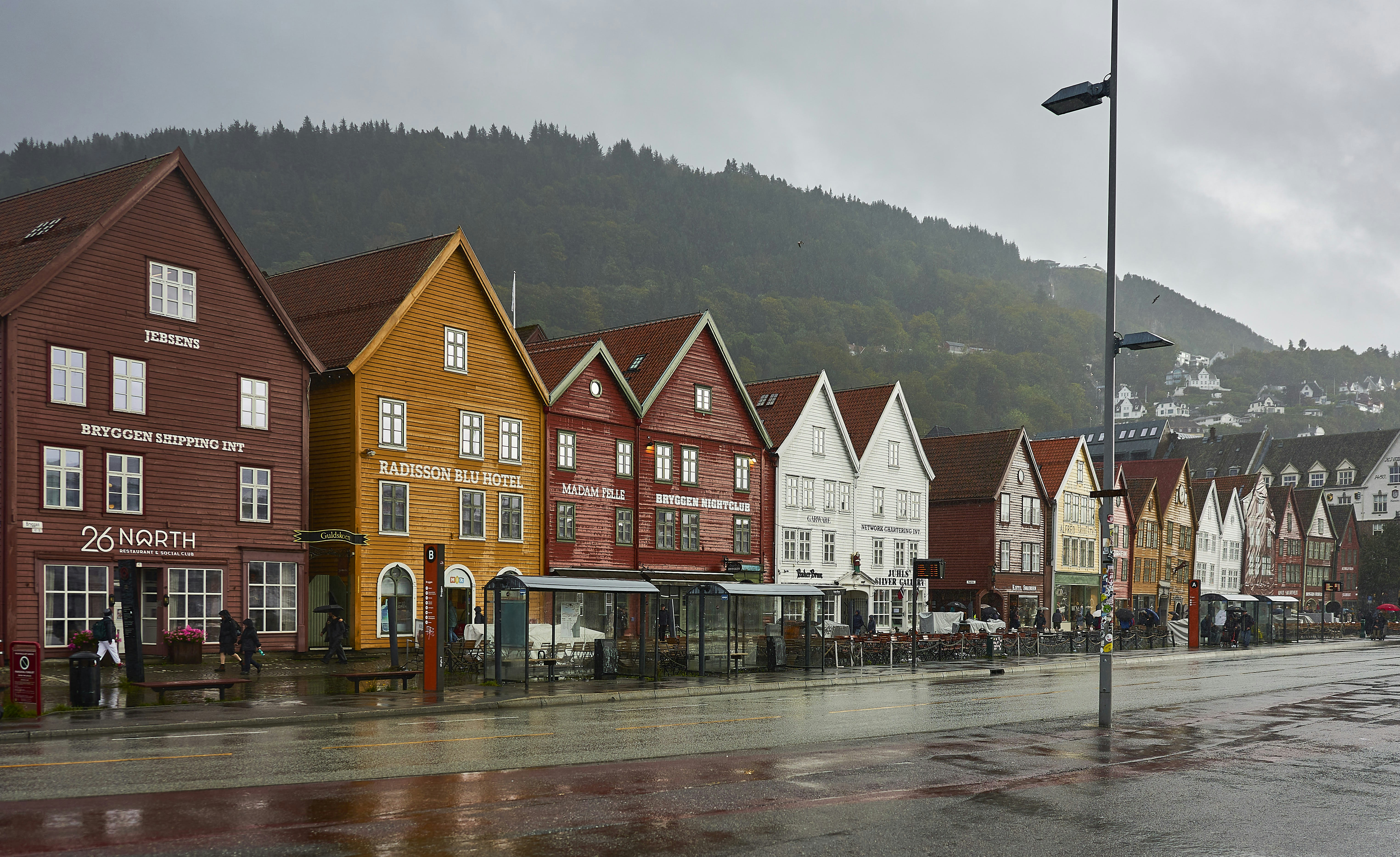 Bunte historische Gebäude säumen eine Straße am Wasser.