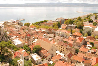 Rooftops of a coastal town with the sea beyond.