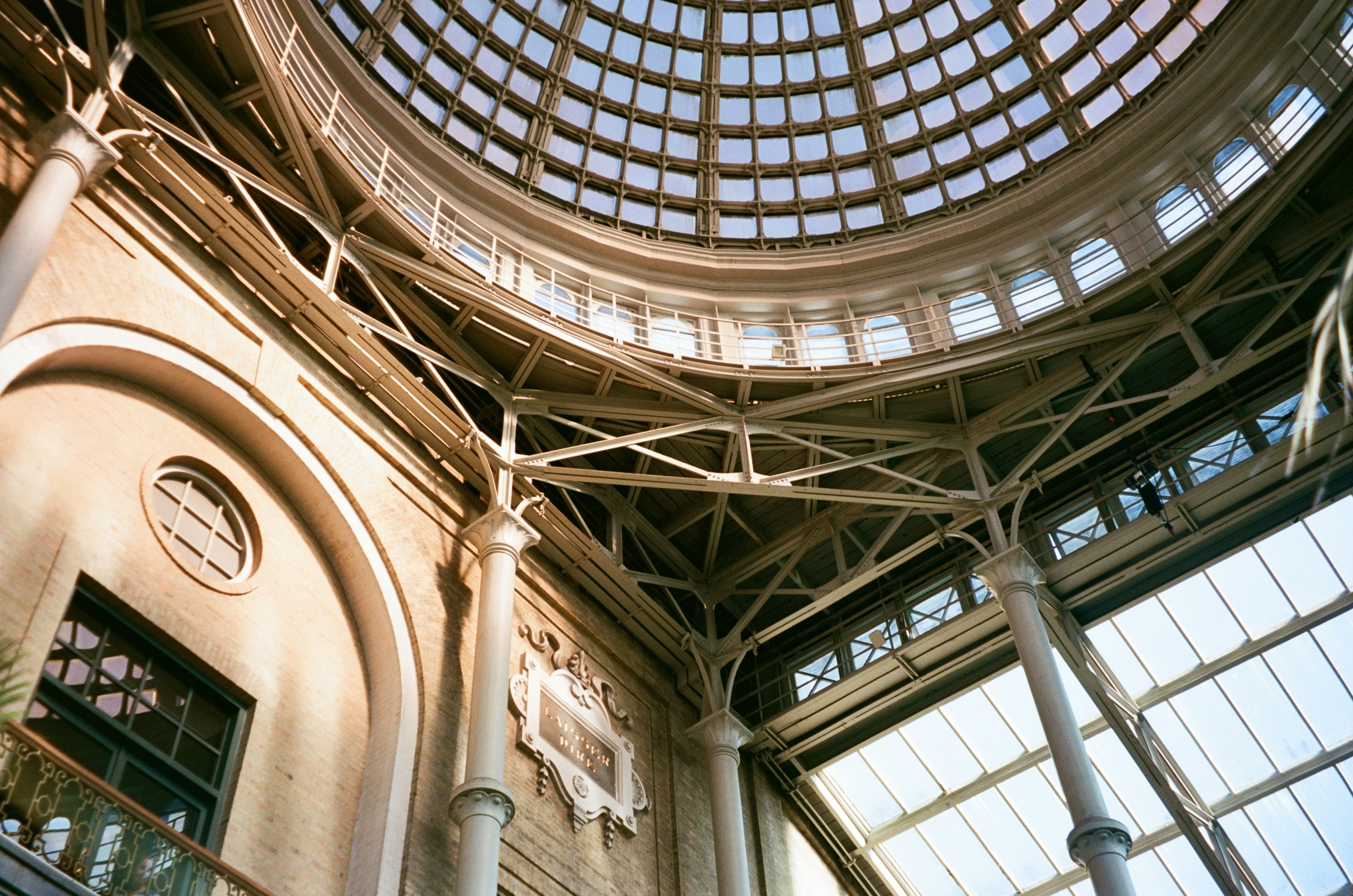 Interior view of a grand rotunda with a glass ceiling.