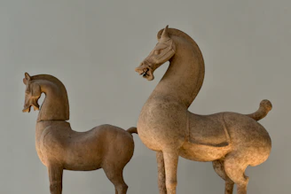 Two ancient terracotta horse sculptures side by side.