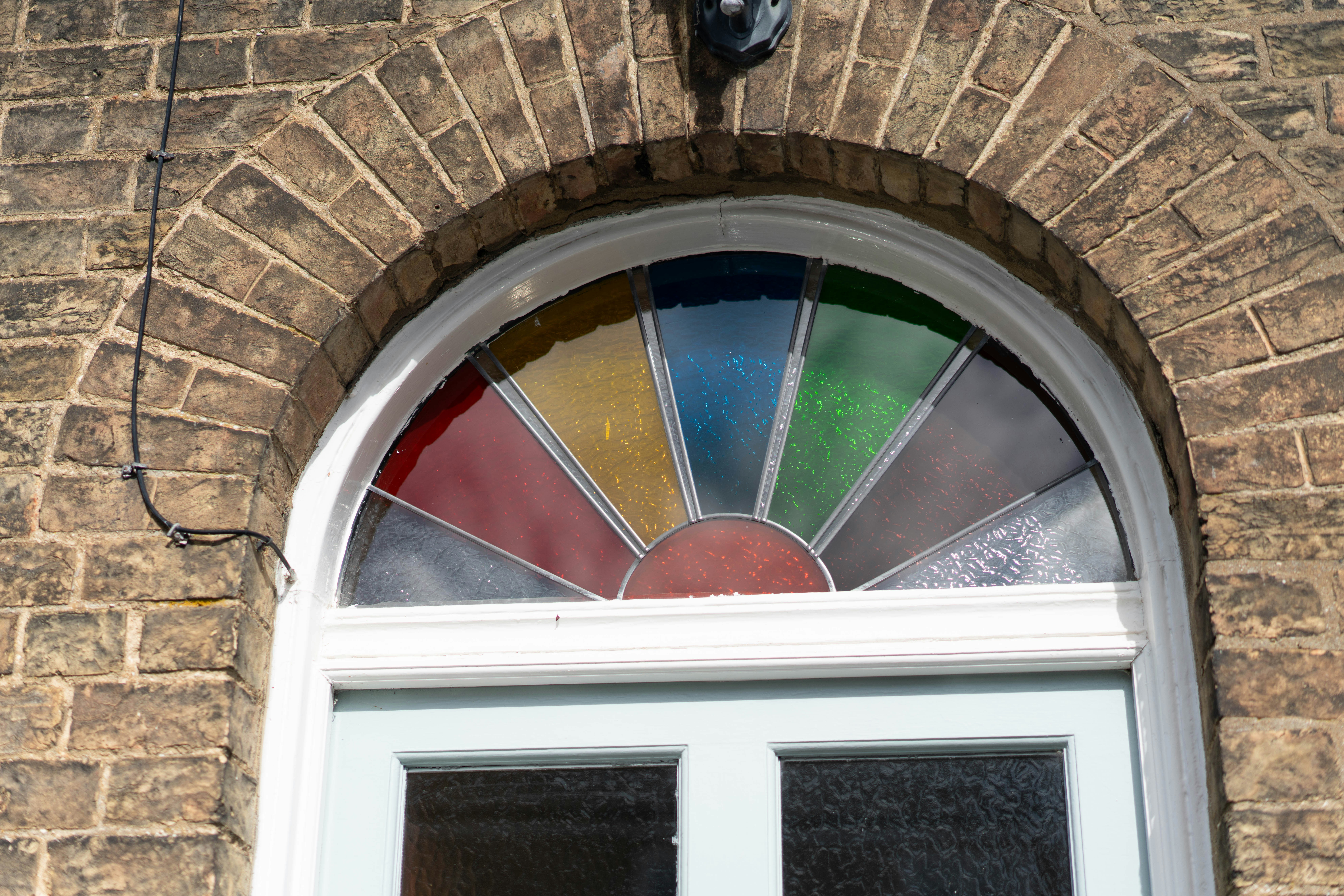 Vidriera arqueada con paneles de colores sobre la puerta - Foto ...