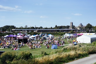 Outdoor festival with tents and many people enjoying themselves.