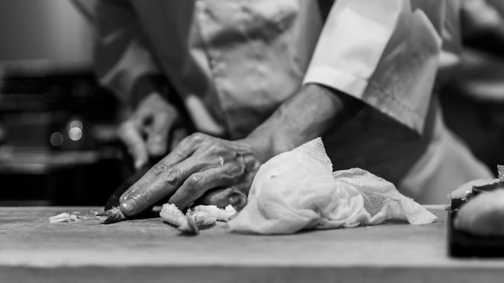 A sushi chef preparing food in a Japanese kitchen