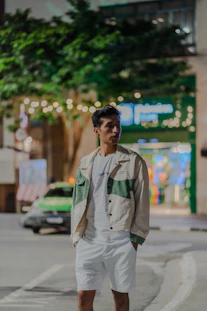 Young man standing on city street at night