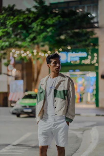 Young man standing on city street at night